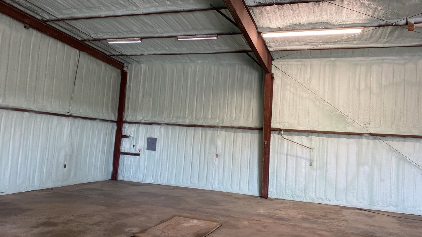 Spray foam insulation on inside of metal industrial building by Straight Edge Roofing Inc