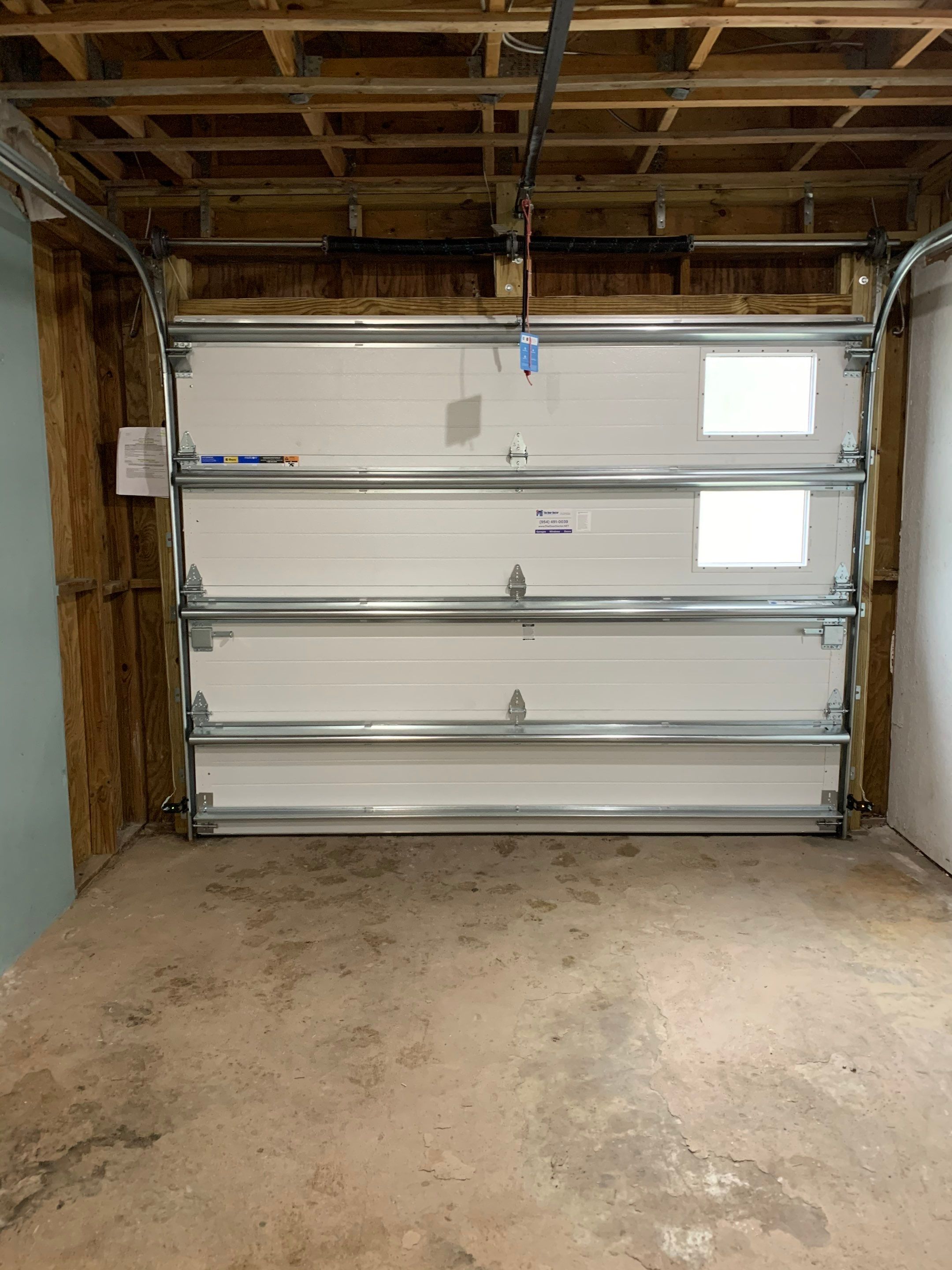 Sectional Garage Door Installation with Wood-Grain Finish in Sunrise - Clopay Modern Steel by The Door Doctor of South Florida, Inc.