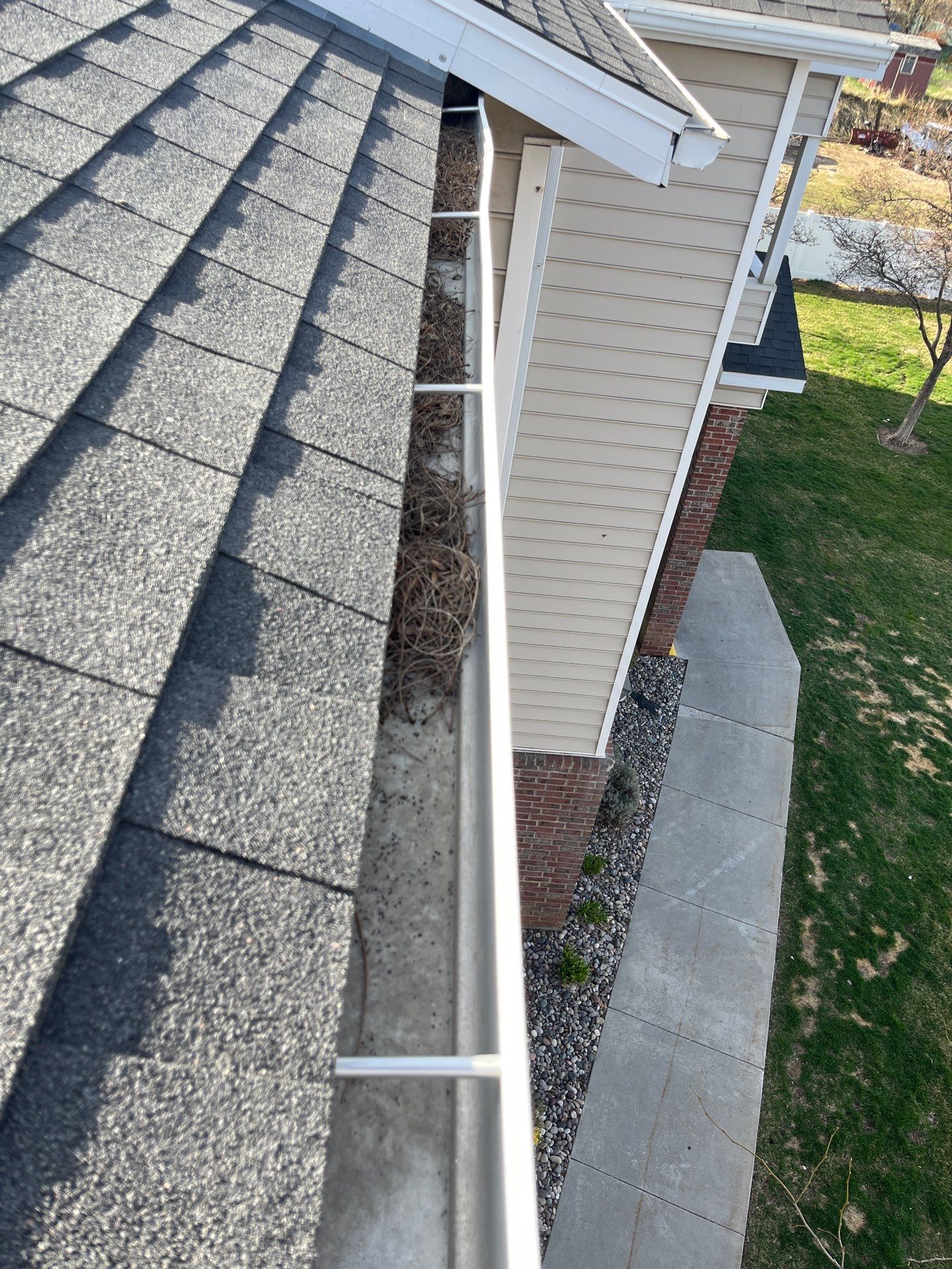 HOA gutter cleaning in Logan, UT before photo showing full gutters