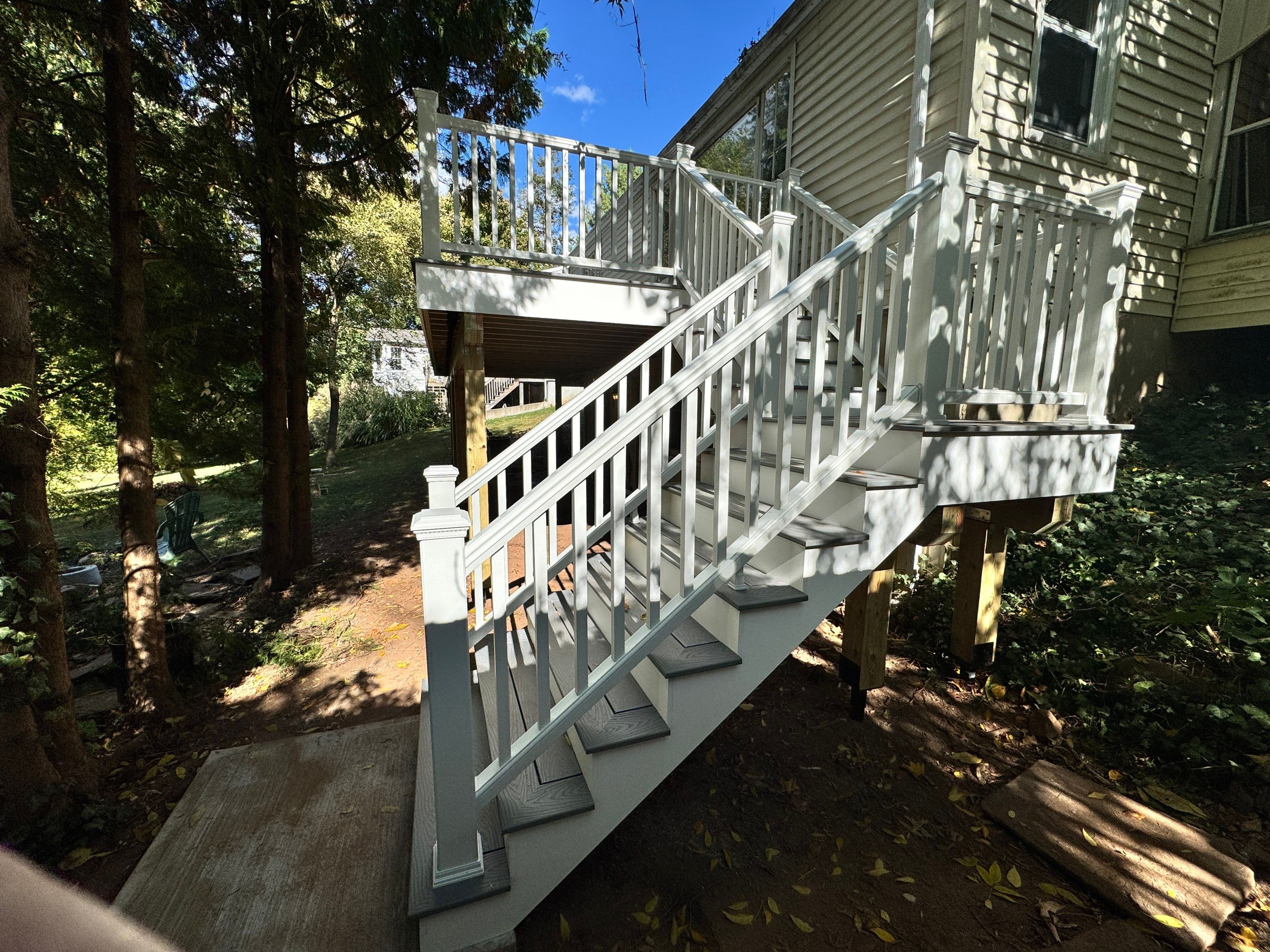 New Deck, Trex Select Pebble Gray boards, Composite railings in white, Trex Rainescape system, and gate. by DiGiorgi Roofing and Siding Inc