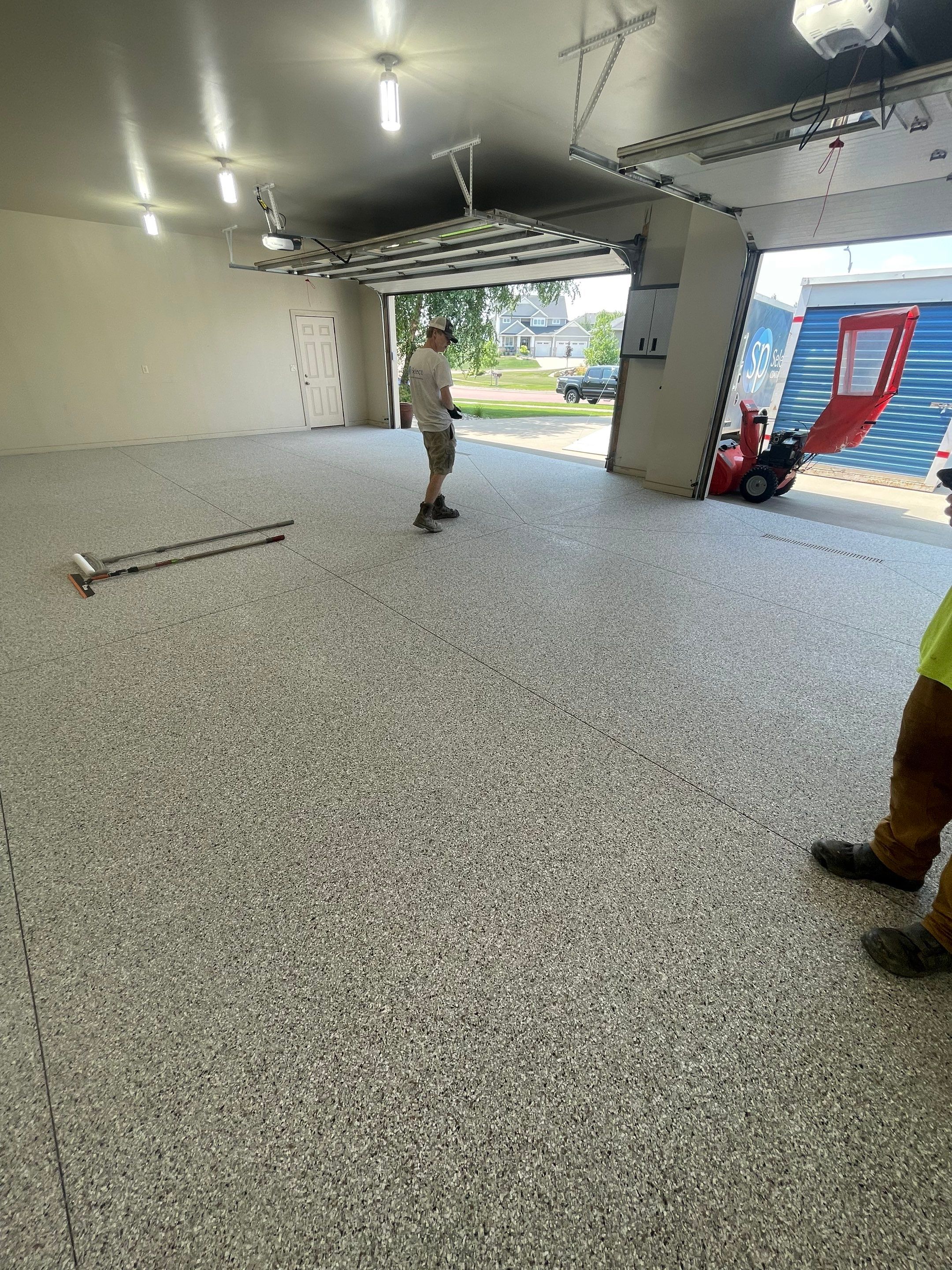 Coyote Flake Garage Floor Coating in Sioux Falls with Trench Drain by Select Painting, Coatings & Garage Cabinets