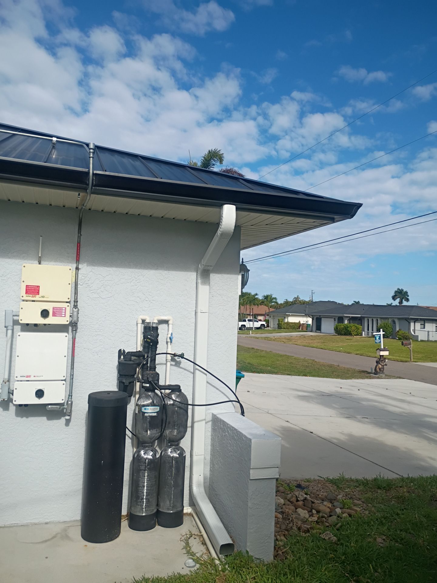 Black Seamless Gutters and White Downspouts in Cape Coral FL by Gutter Professors