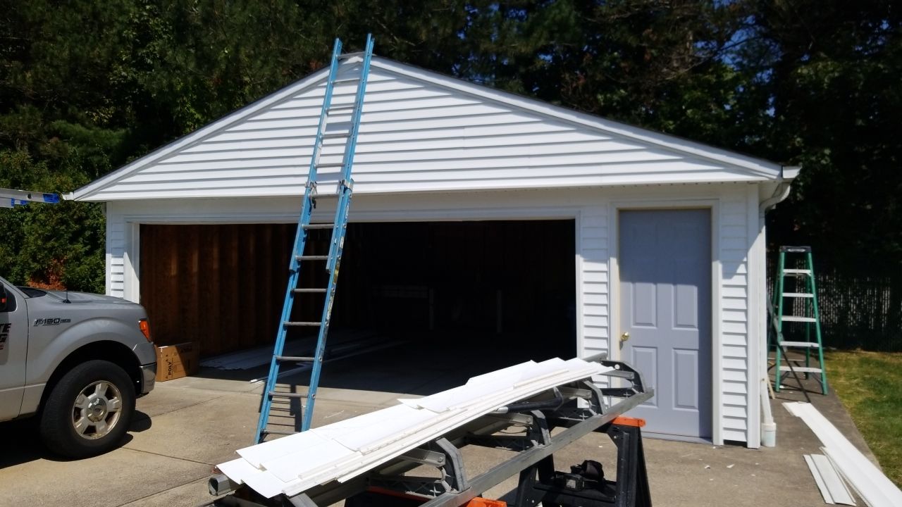 Siding Installation using Norandex woodsman dl-5 white woodgrain vinyl by Absolute Roofing and Construction