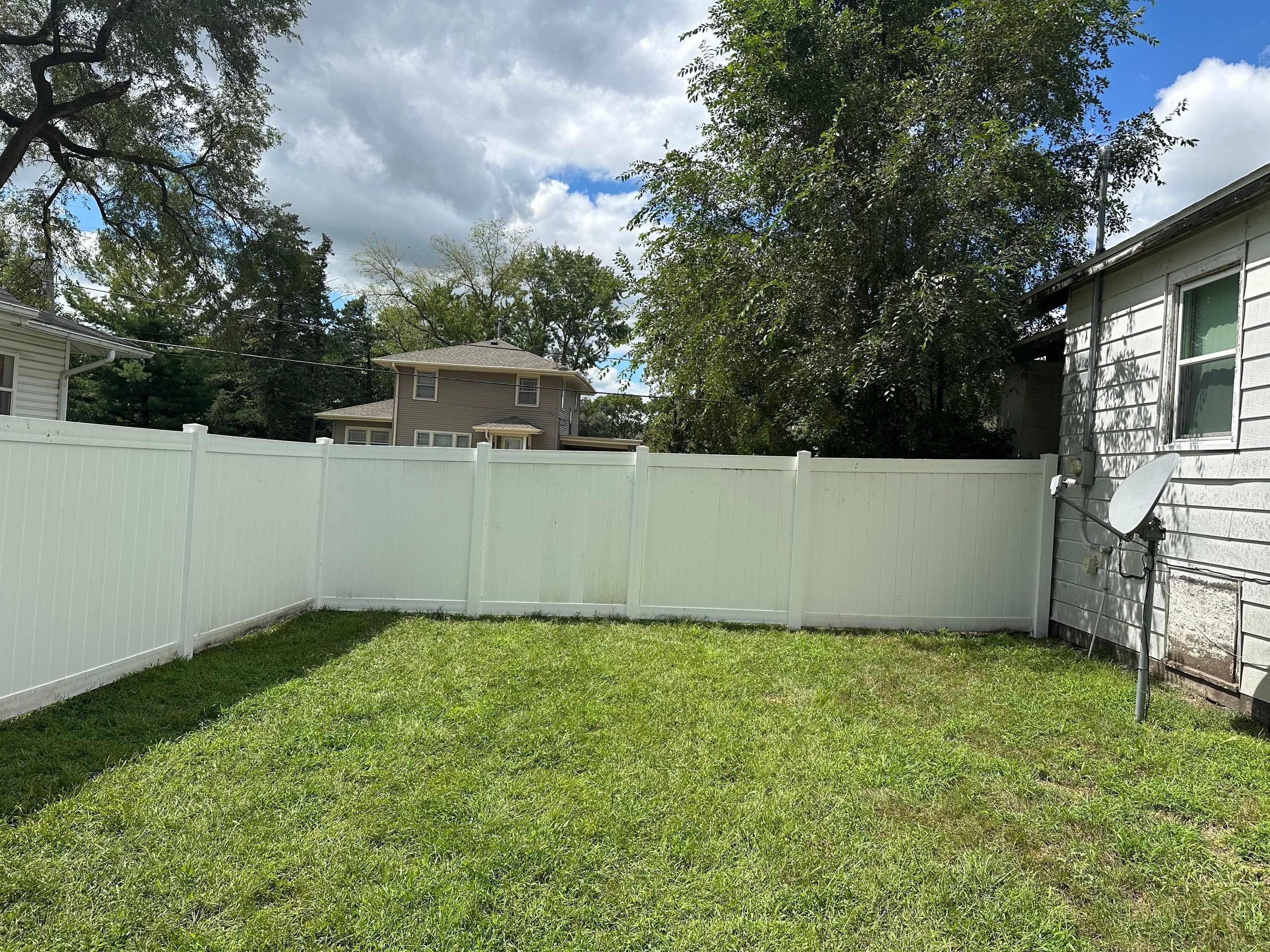 Residential White Vinyl Privacy Fence Installation in Waterloo, Iowa by Perfect Picket Fence and Stain