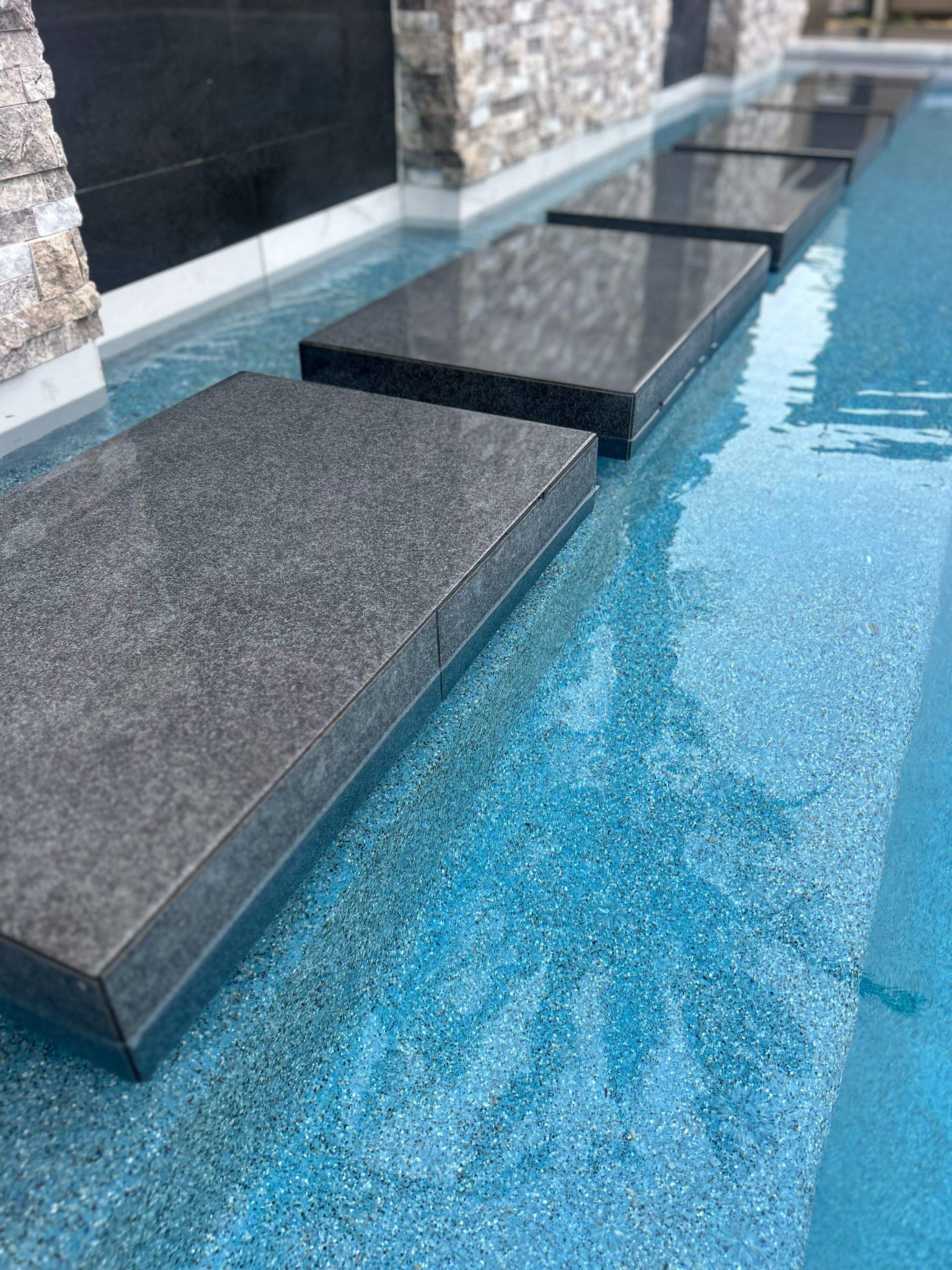Pool spa zero edge spa, large water wall, floating steps, bar stools by Premier Pools and Spas Temecula