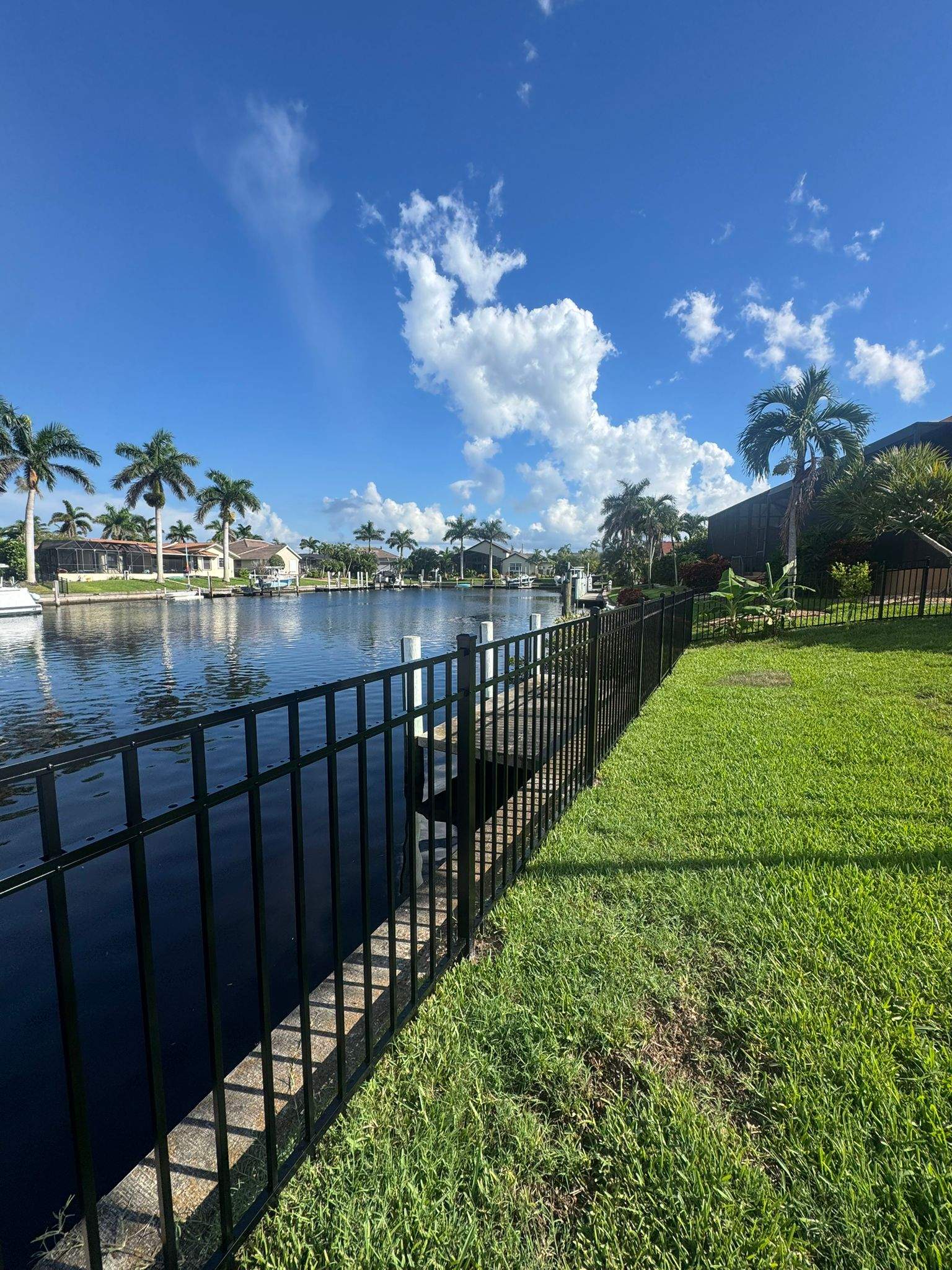 Black Aluminum Fence Installation Along Punta Gorda Canal by True Fence LLC