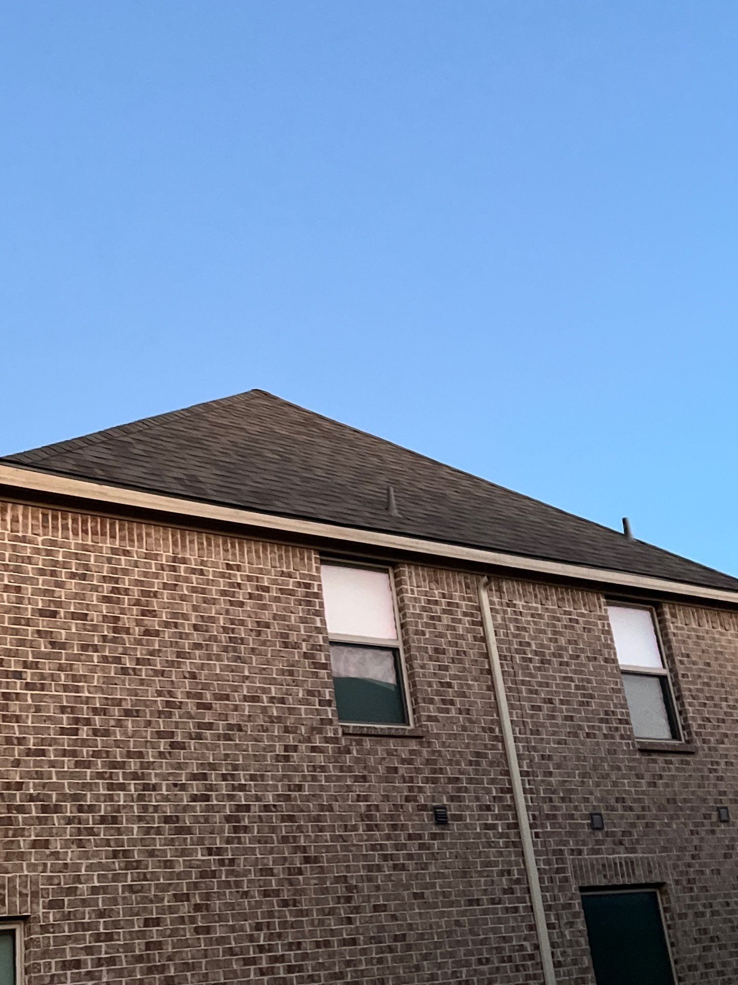 Brown brick/mixed stone with Malarkey Natural Wood by Tejas Roofworks + Restoration