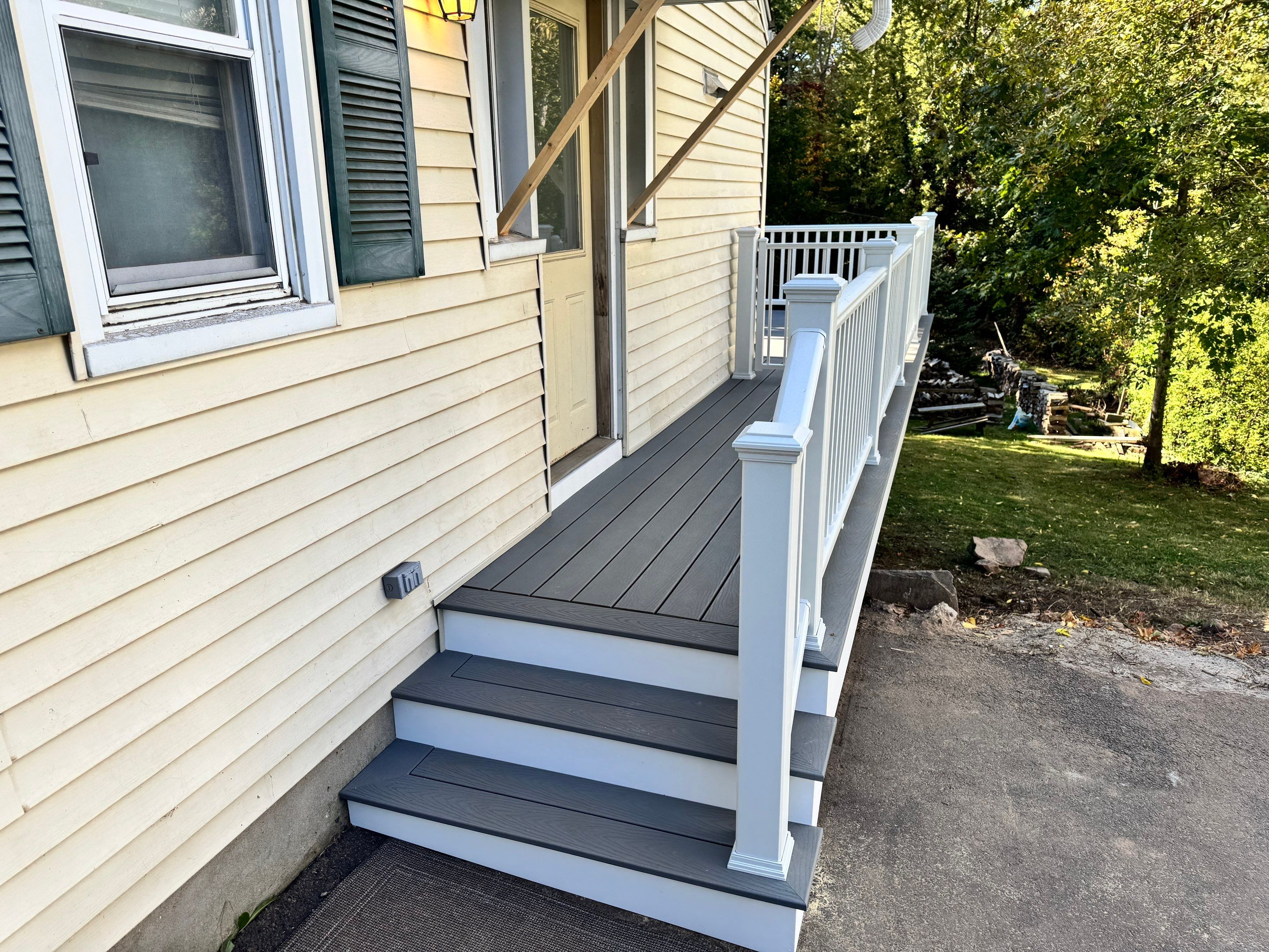 New Deck, Trex Select Pebble Gray boards, Composite railings in white, Trex Rainescape system, and gate. by DiGiorgi Roofing and Siding Inc