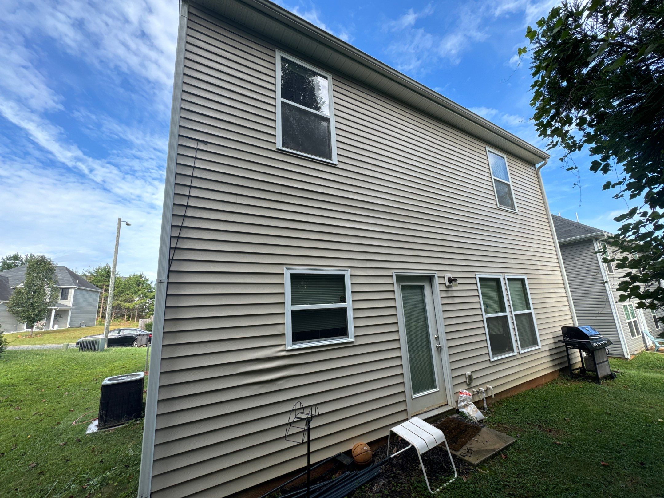 the service shown is cleaning the vinyl siding of a residential house using pressure washing techniques to remove dirt and grime