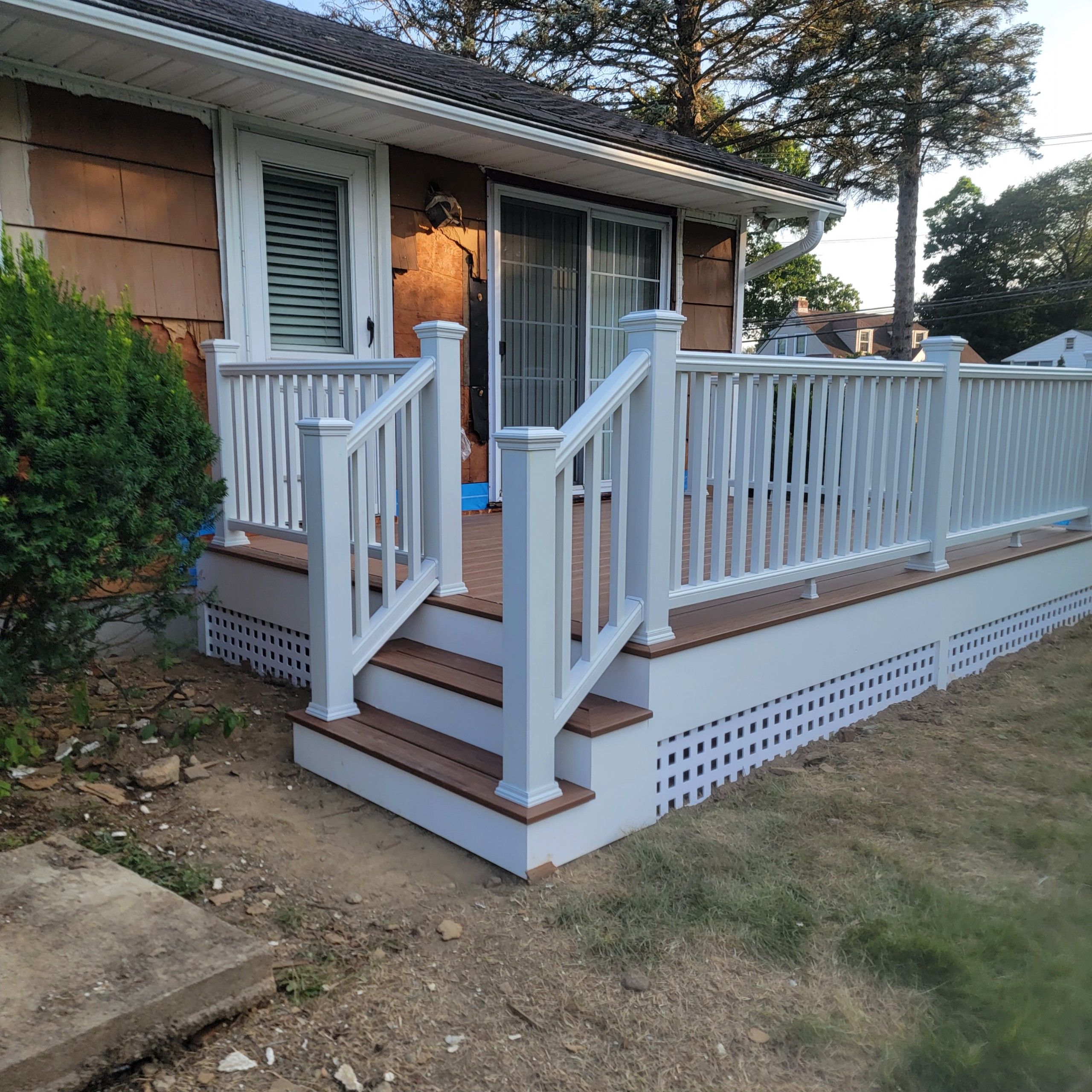 Deck Replacement using Trex Tropical Tiki Torch and White Transcend railings with lattice bottom by DiGiorgi Roofing and Siding Inc