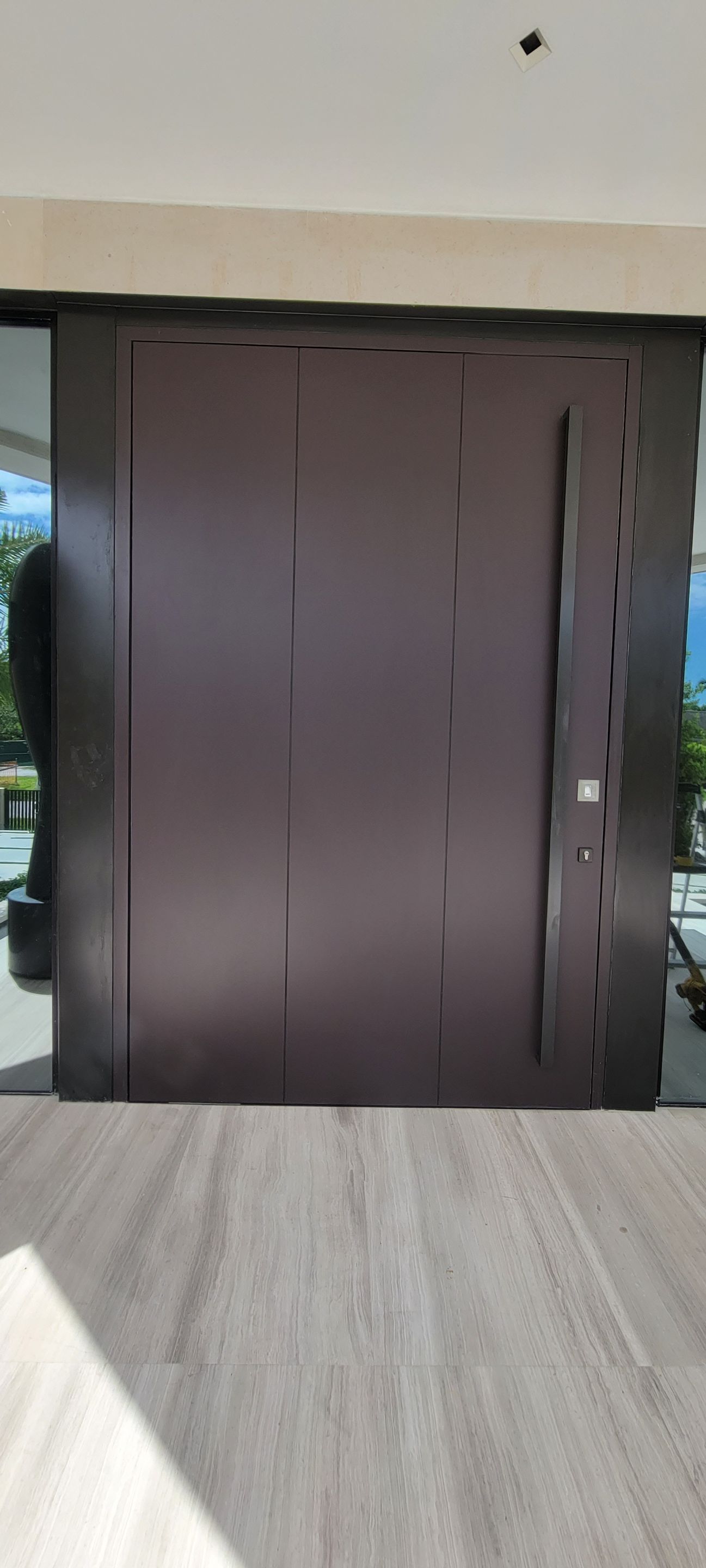 Custom Material Pivot Door installation by Impact Precious Wood Inc.