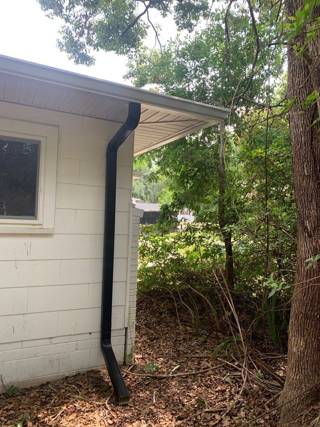 White Seamless Gutters and Black Downspouts by Gutter Professors