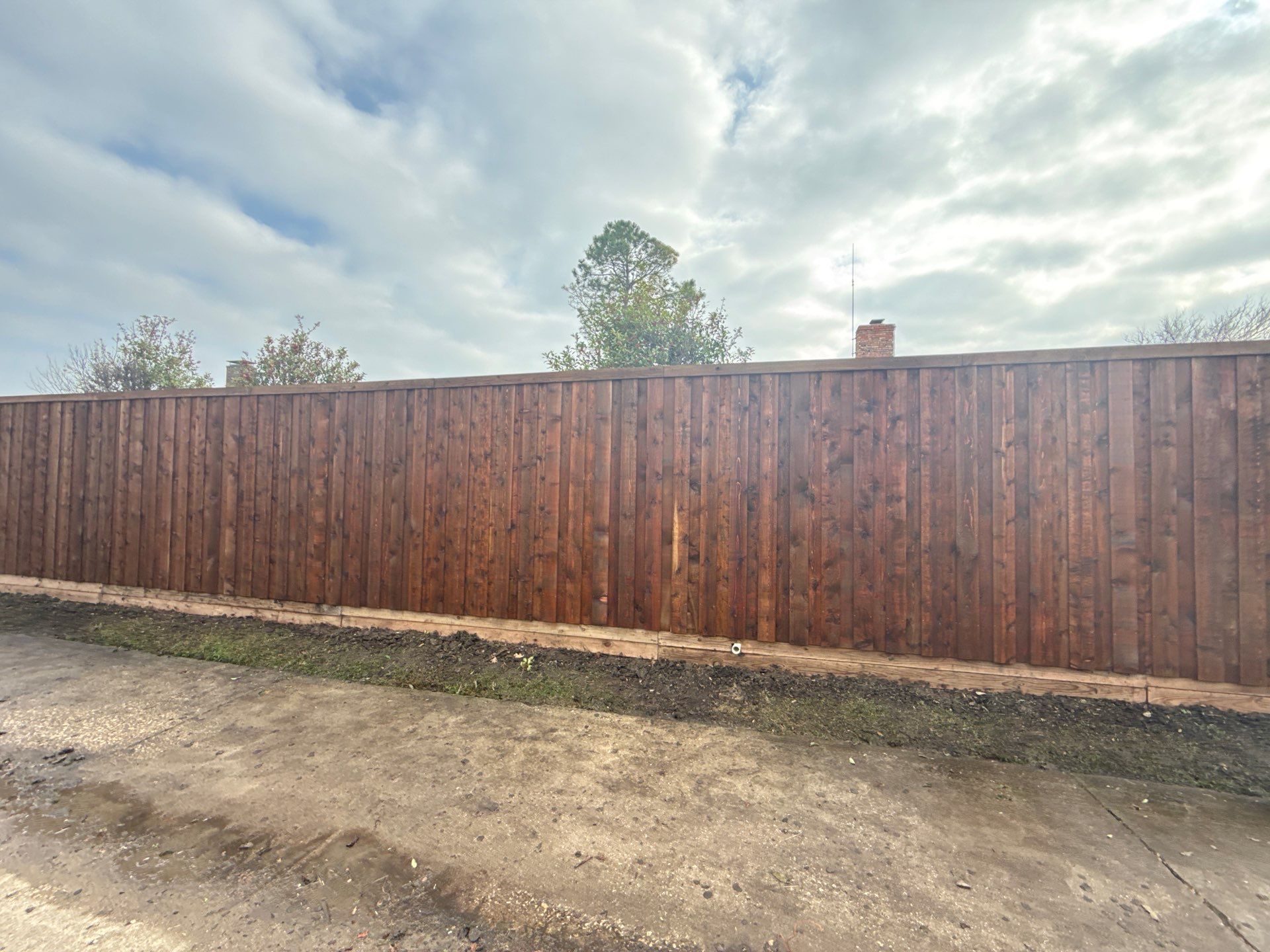Pre-Stained board on board w/ trim and kickboard using 1x4 cedar trim by Grizzly Fence And Patio
