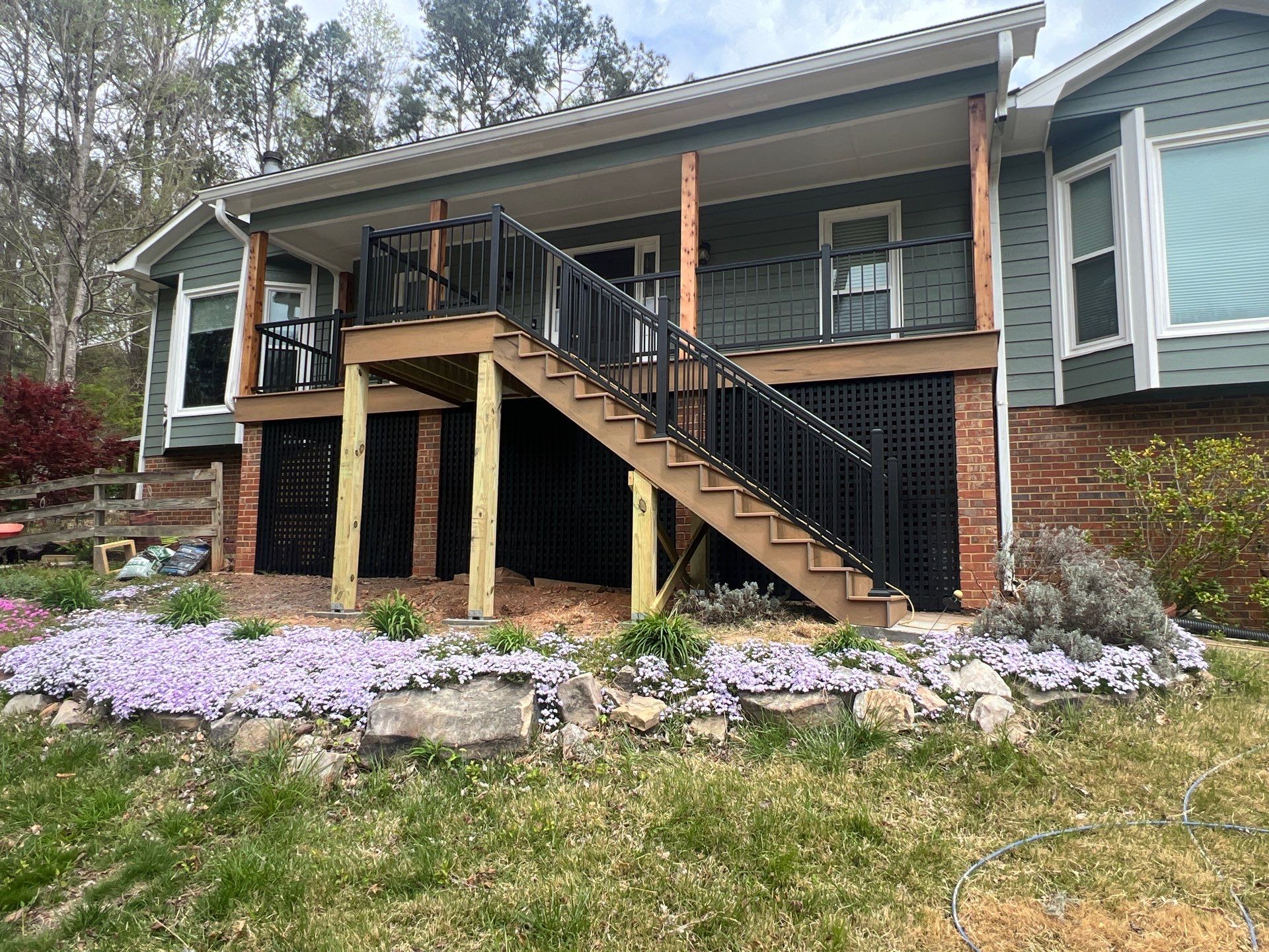 Composite Deck and Porch Renovation With Black Metal Railings by Swift Home Renovations 