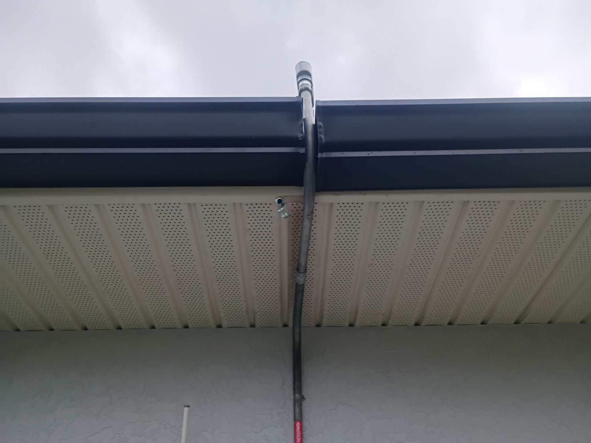 Black Seamless Gutters and White Downspouts in Cape Coral FL by Gutter Professors