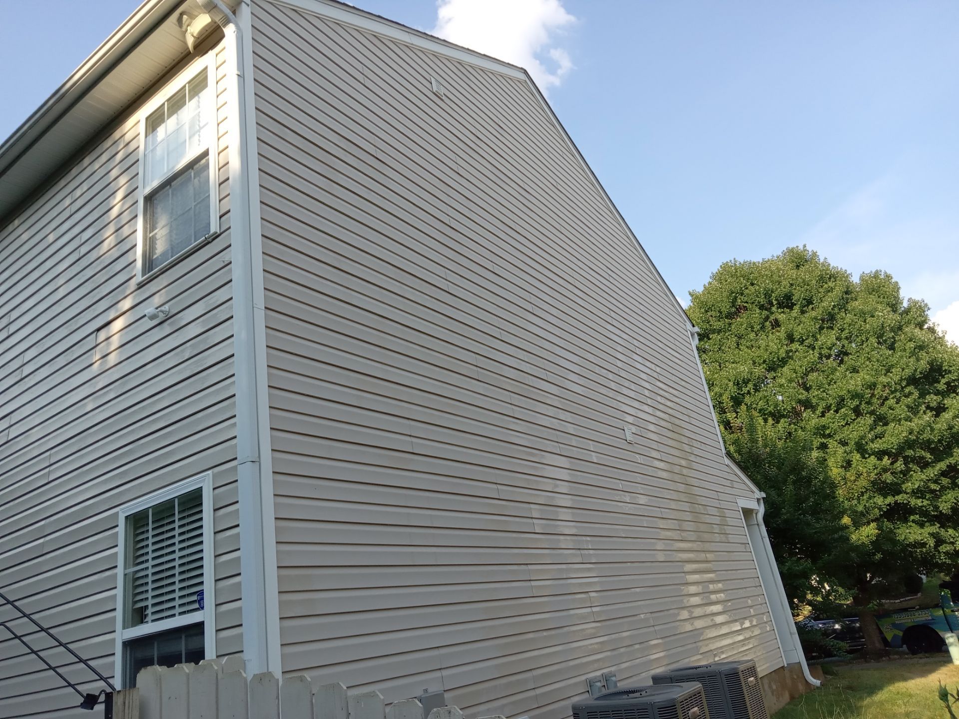 pressure washing vinyl siding on the exterior of a residential house removing dirt and grime for a cleaner appearance