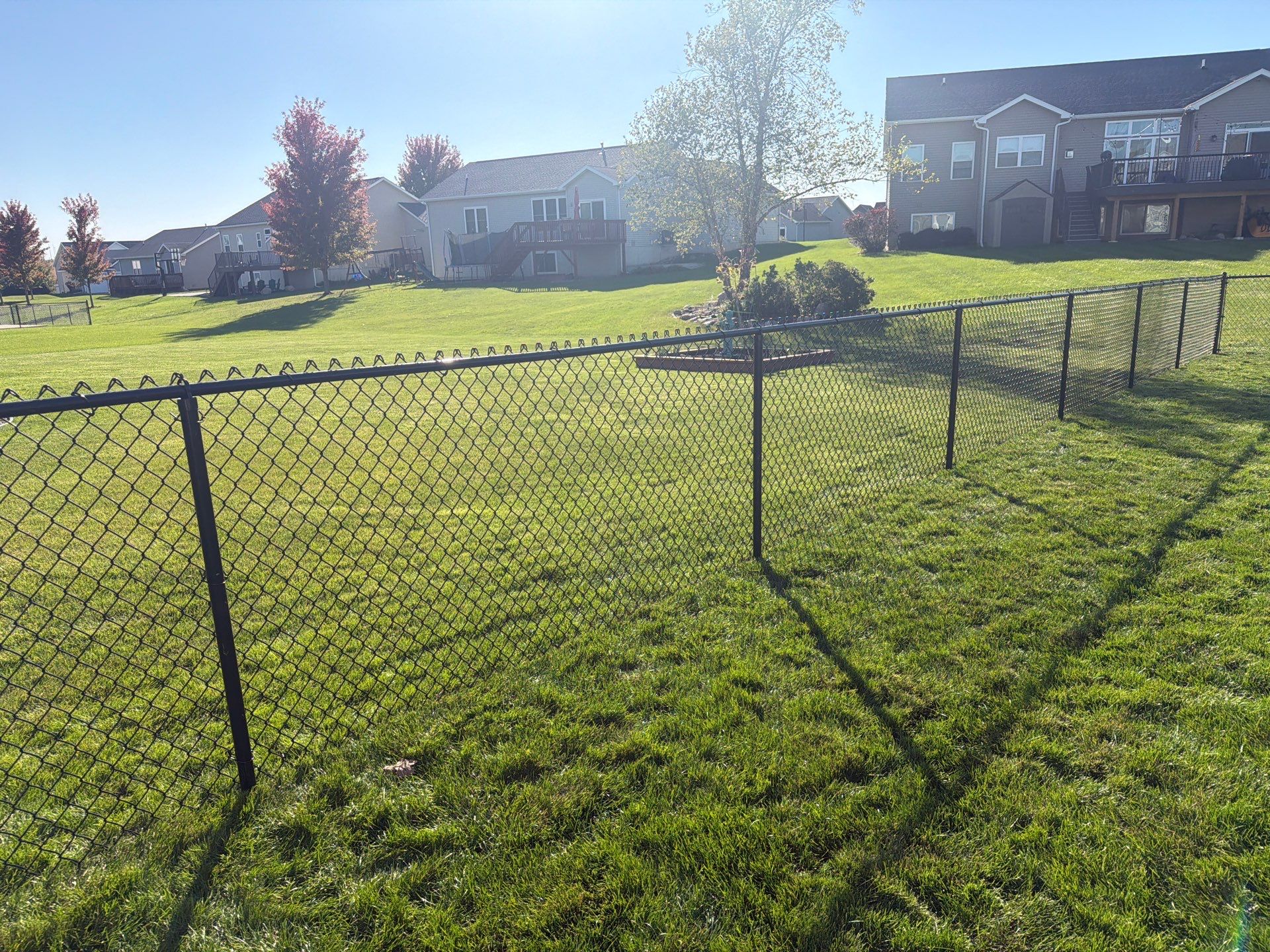 Black Vinyl-Coated Chain Link Fence Installation in Cedar Falls by Perfect Picket Fence and Stain