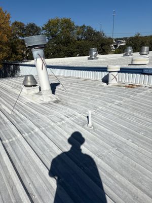Wide view of a completed metal roof with vents