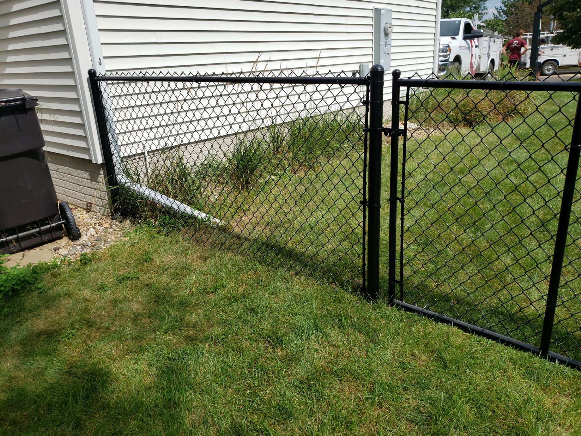 Black Vinyl-Coated Chain Link Fence Installation in Cedar Falls by Perfect Picket Fence and Stain