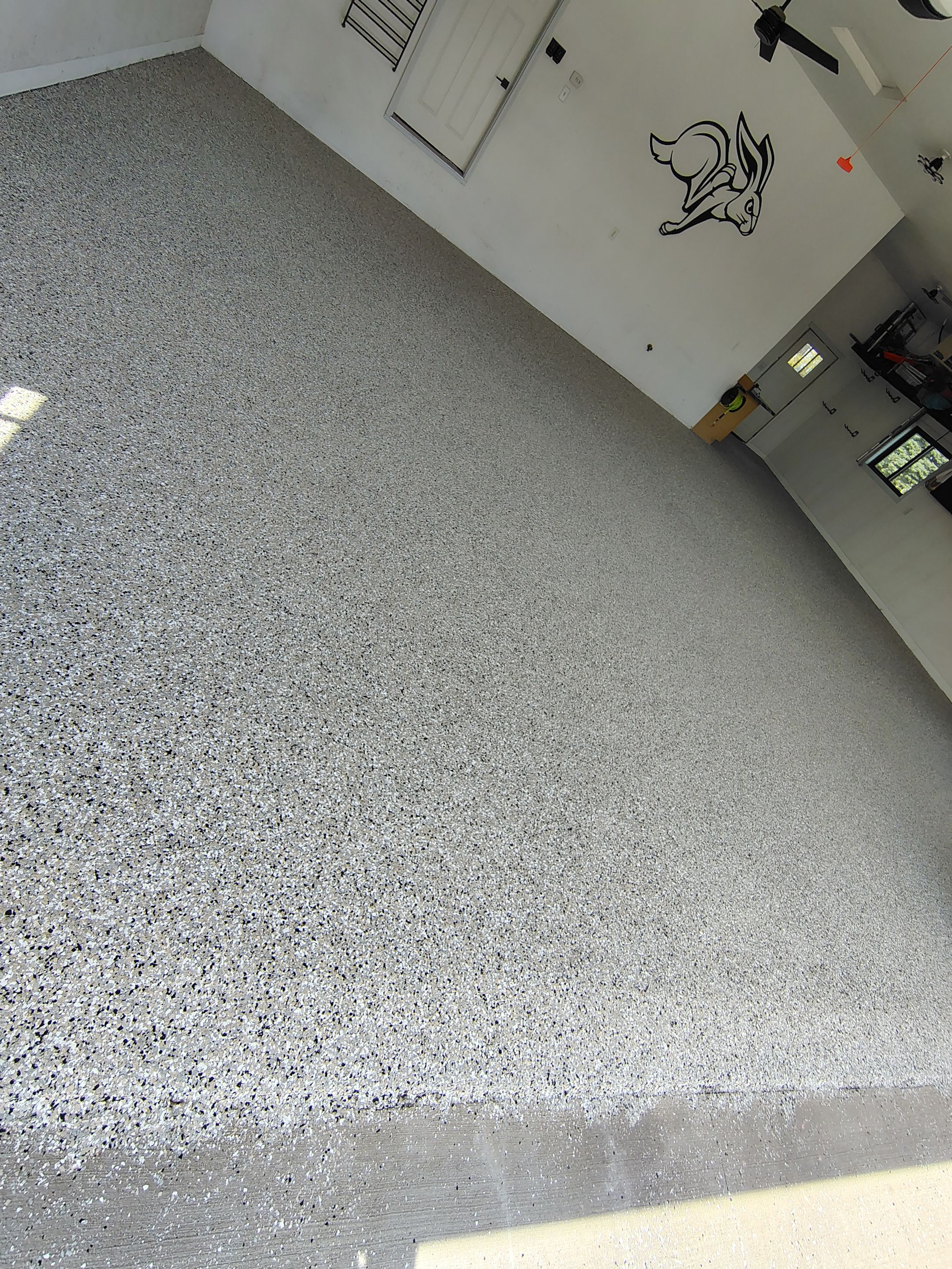 Speckled Polyaspartic Garage Floor Coating Installation in Dell Rapids by Select Painting, Coatings & Garage Cabinets