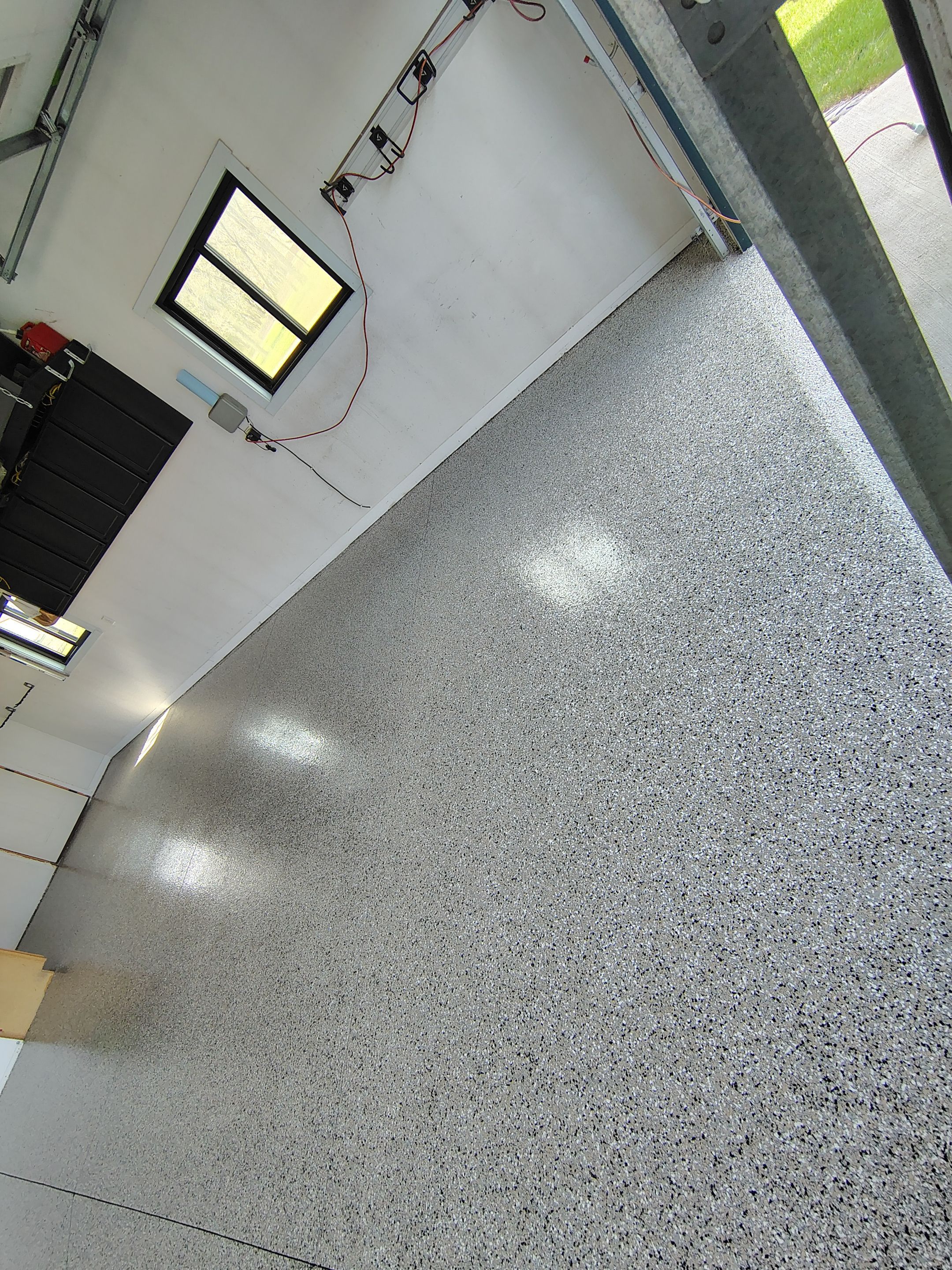 Speckled Polyaspartic Garage Floor Coating Installation in Dell Rapids by Select Painting, Coatings & Garage Cabinets