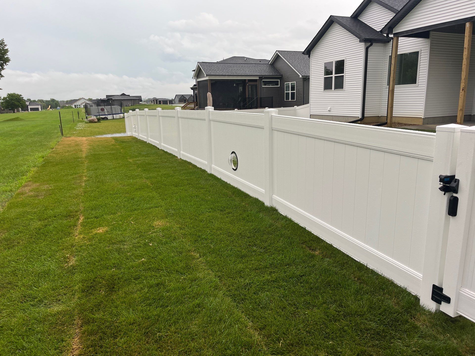 White Vinyl Privacy Fence With Pet Window in Cedar Falls by Perfect Picket Fence and Stain