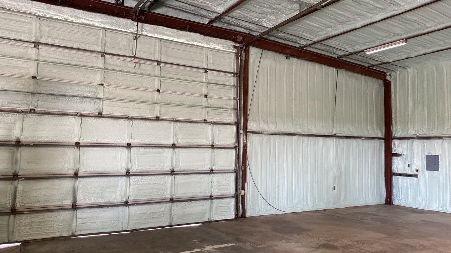 Spray foam insulation on inside of metal industrial building by Straight Edge Roofing Inc