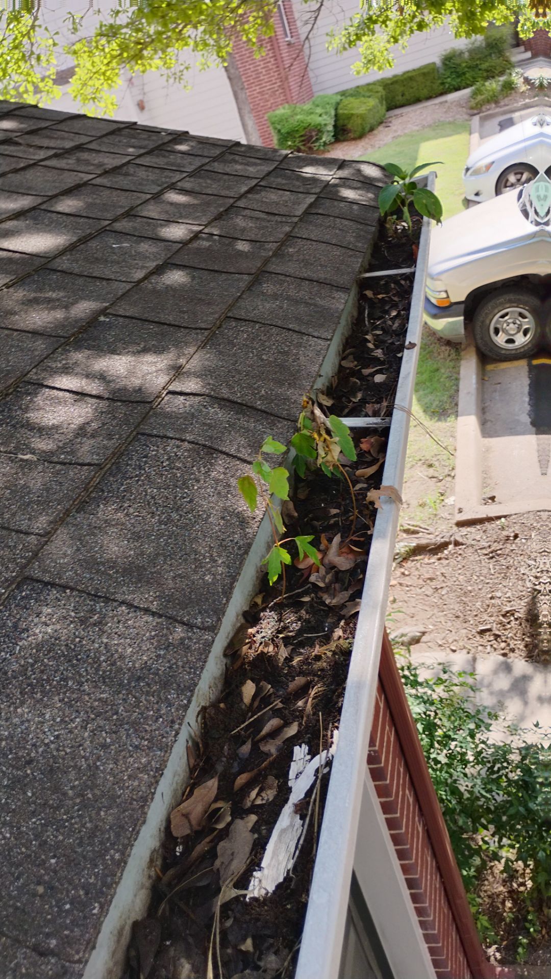 Commercial gutter cleaning Oklahoma before photo with filled gutters