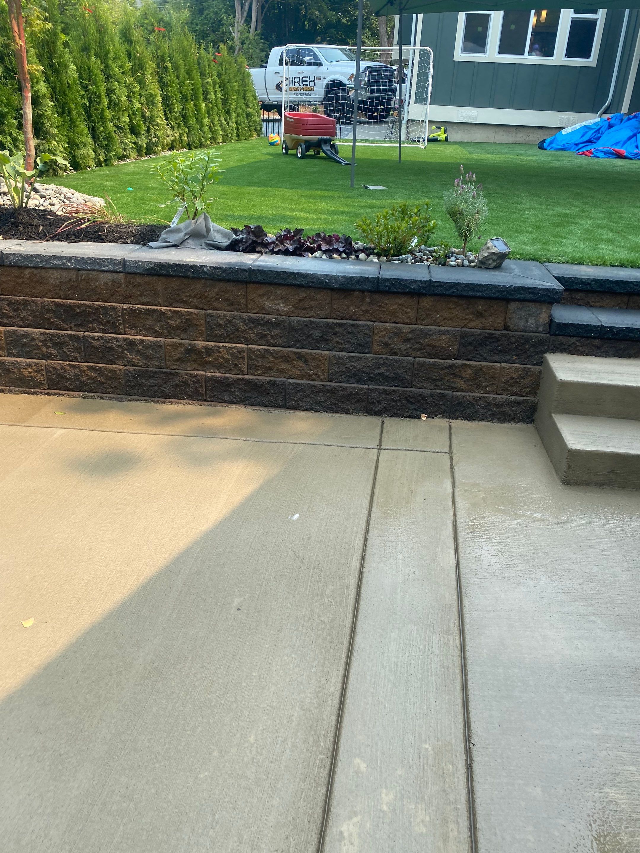 Patio Installation using Concrete, Retaining walls, and Turf install by Jireh Asphalt & Concrete Inc 