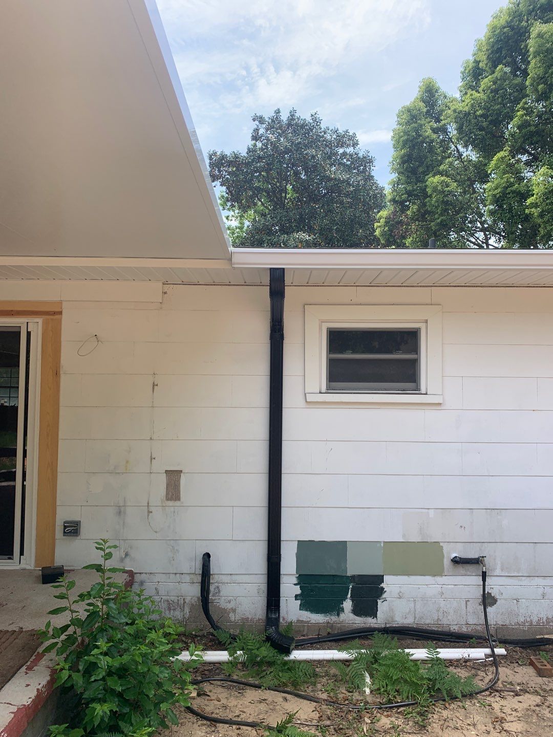 White Seamless Gutters and Black Downspouts by Gutter Professors