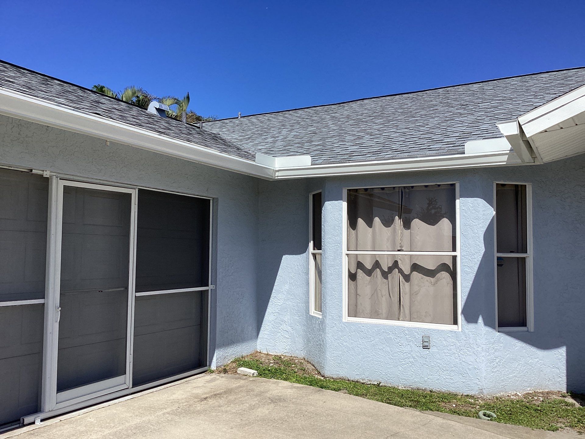 New White Seamless Gutters with Downspouts and Splash Guards in Cape Coral FL by Gutter Professors
