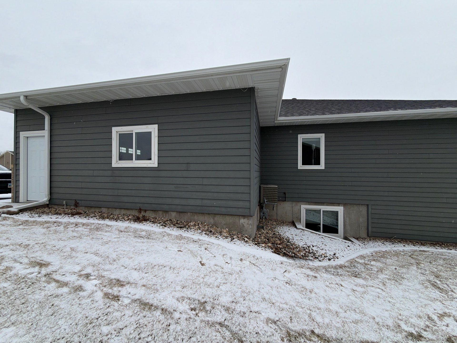 Madison Exterior Remodel with Dark Gray Siding and Stone Accents by Select Painting, Coatings & Garage Cabinets