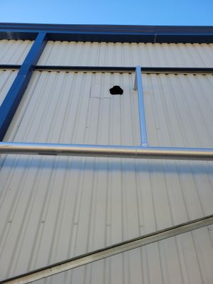 Hole in exterior white metal roof panel