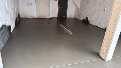 Concrete garage floor replacement with a broom finished apron and wall repair