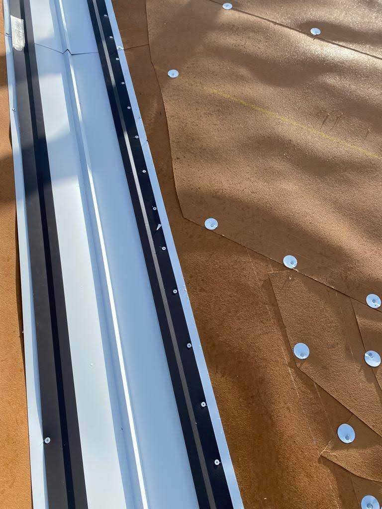 Standing Seam Metal & Flat Re-Roof using 1.5" Nail Strip 24ga Solar White Kynar Coated Standing Seam Metal Panels by Morton Roofing, Inc.