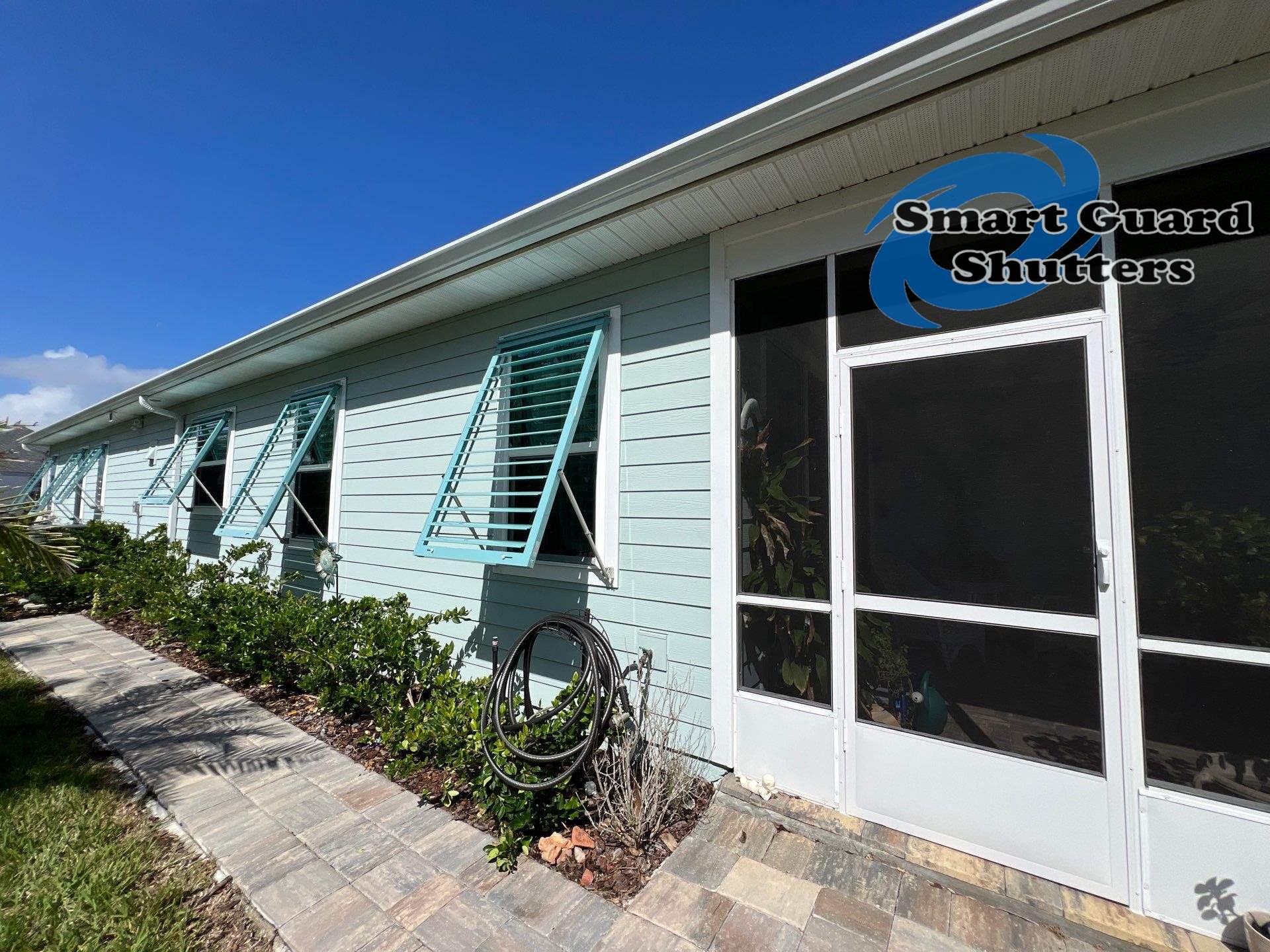 Impact Bahama Shutters in Pastel Turquoise by Smart Guard Shutters