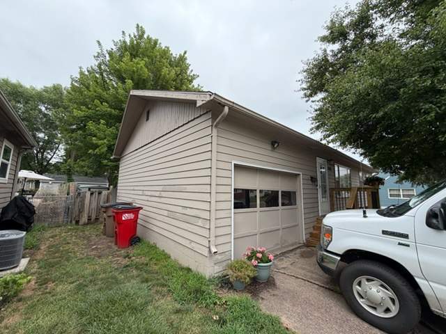 Dark Blue Exterior Painting and Trim Refresh in Sioux Falls by Select Painting, Coatings & Garage Cabinets