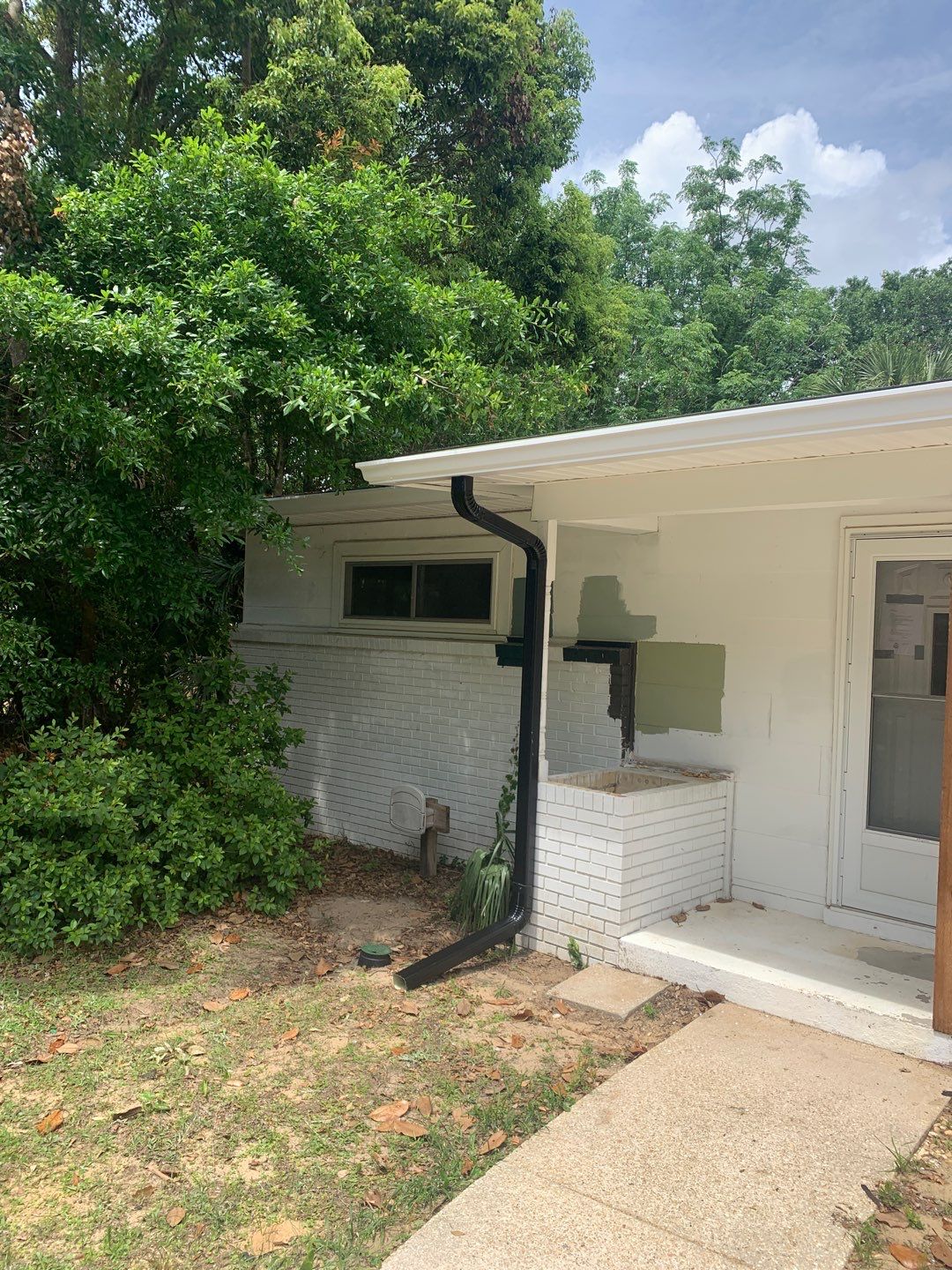 White Seamless Gutters and Black Downspouts by Gutter Professors