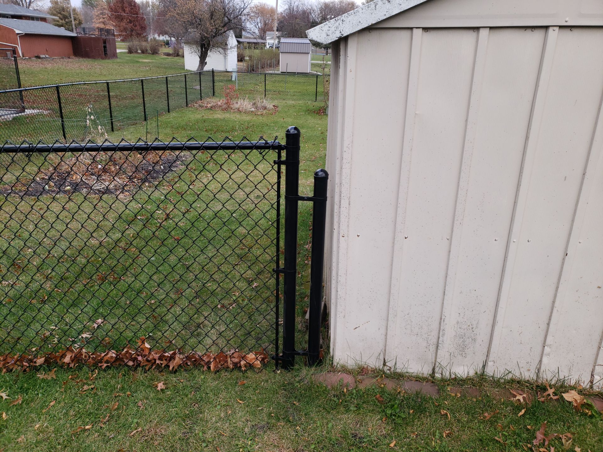 Residential Black Vinyl-Coated Chain Link Fence in Grundy Center by Perfect Picket Fence and Stain