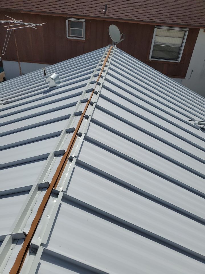 Residential Roofing Installation using 1.5" Nail Strip 24ga Solar White Kynar Coated Standing Seam Metal Panels by Morton Roofing, Inc.