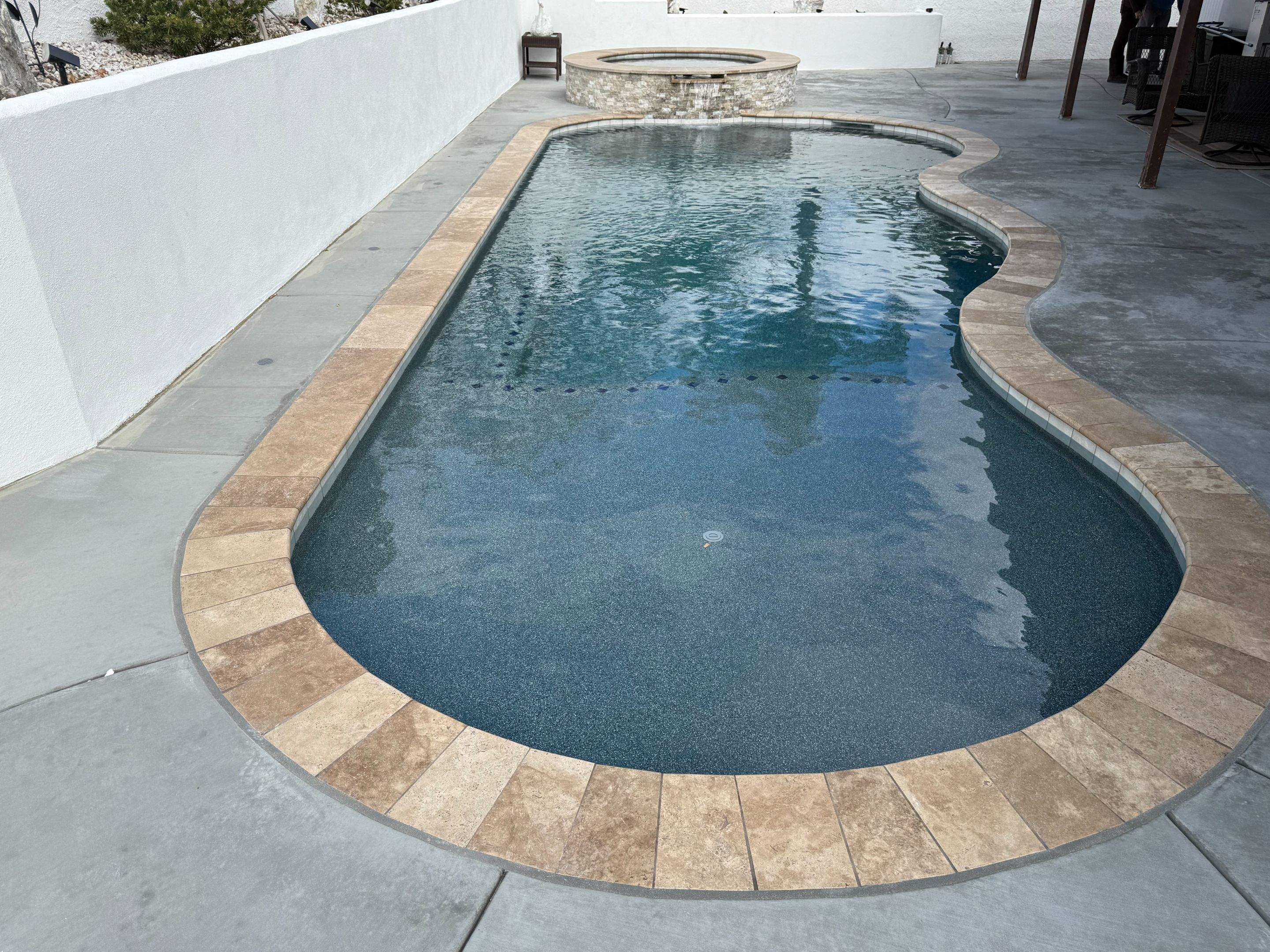 Pool and spa freeform travertine coping by Premier Pools and Spas Temecula