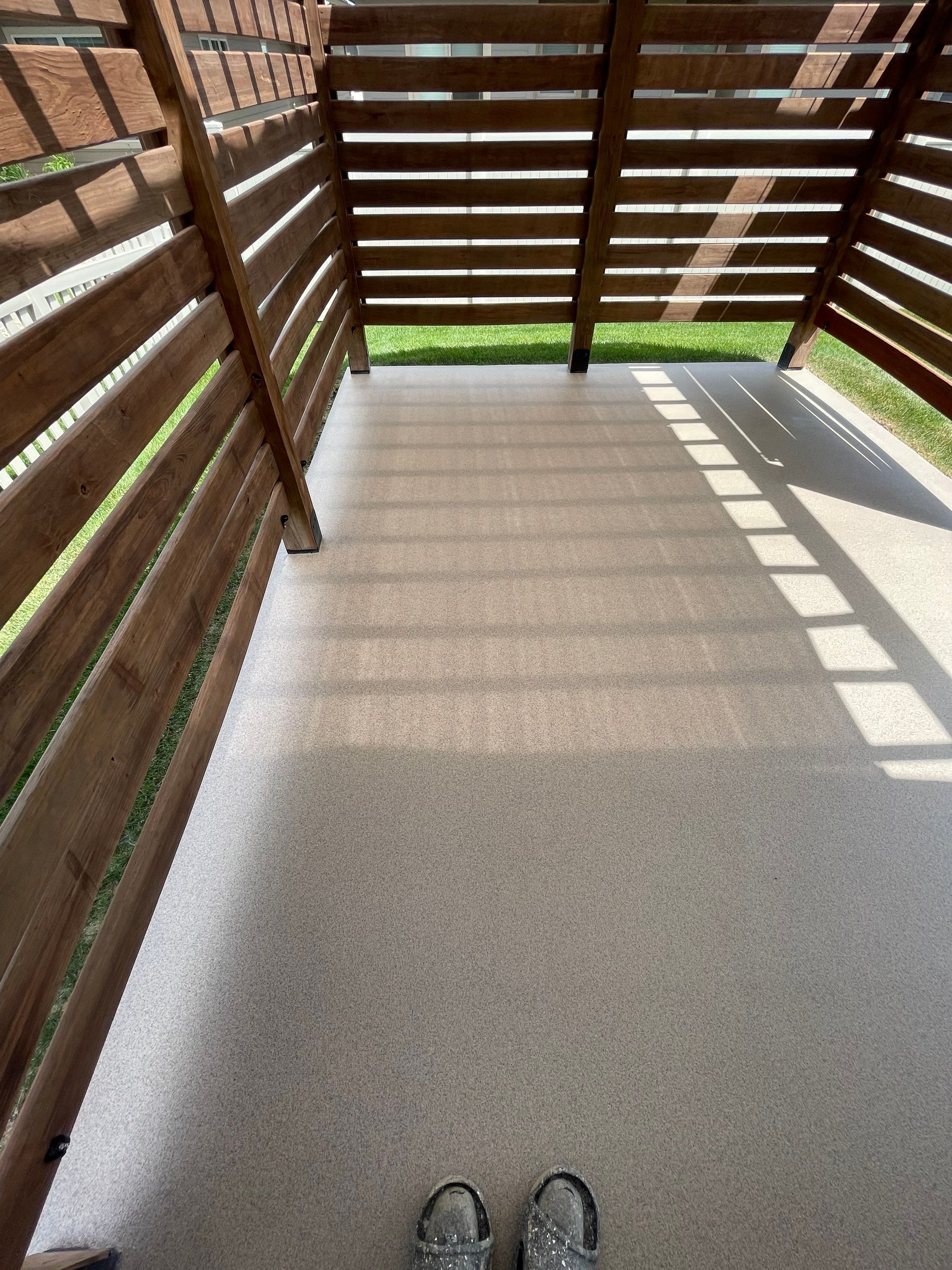 Textured Concrete Patio Coating and Custom Privacy Pergola in Sioux Falls by Select Painting, Coatings & Garage Cabinets