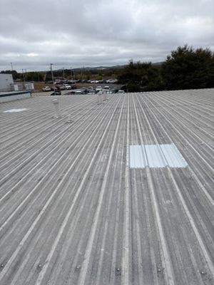 Wide view of a completed industrial metal roof installation.