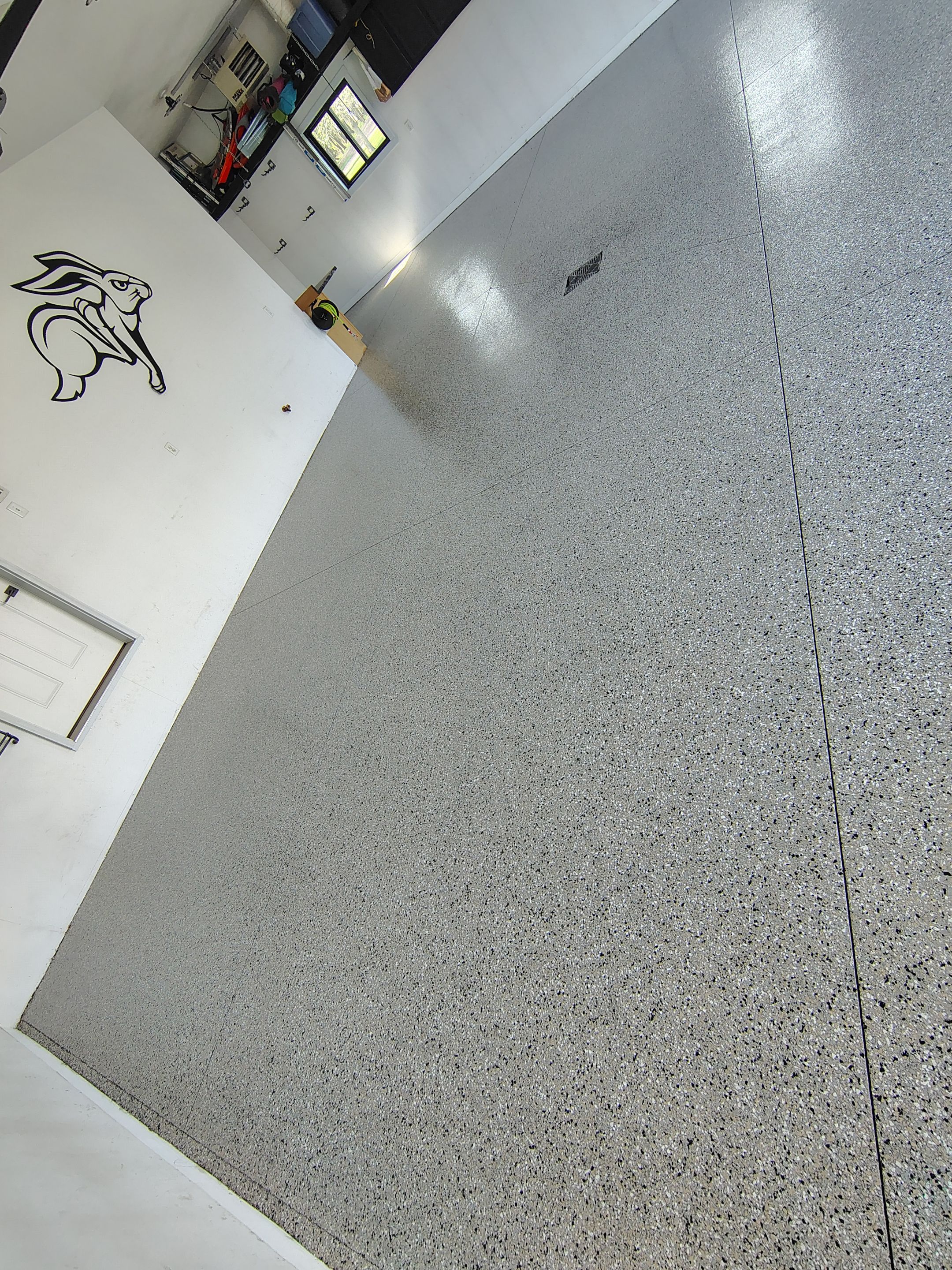 Speckled Polyaspartic Garage Floor Coating Installation in Dell Rapids by Select Painting, Coatings & Garage Cabinets