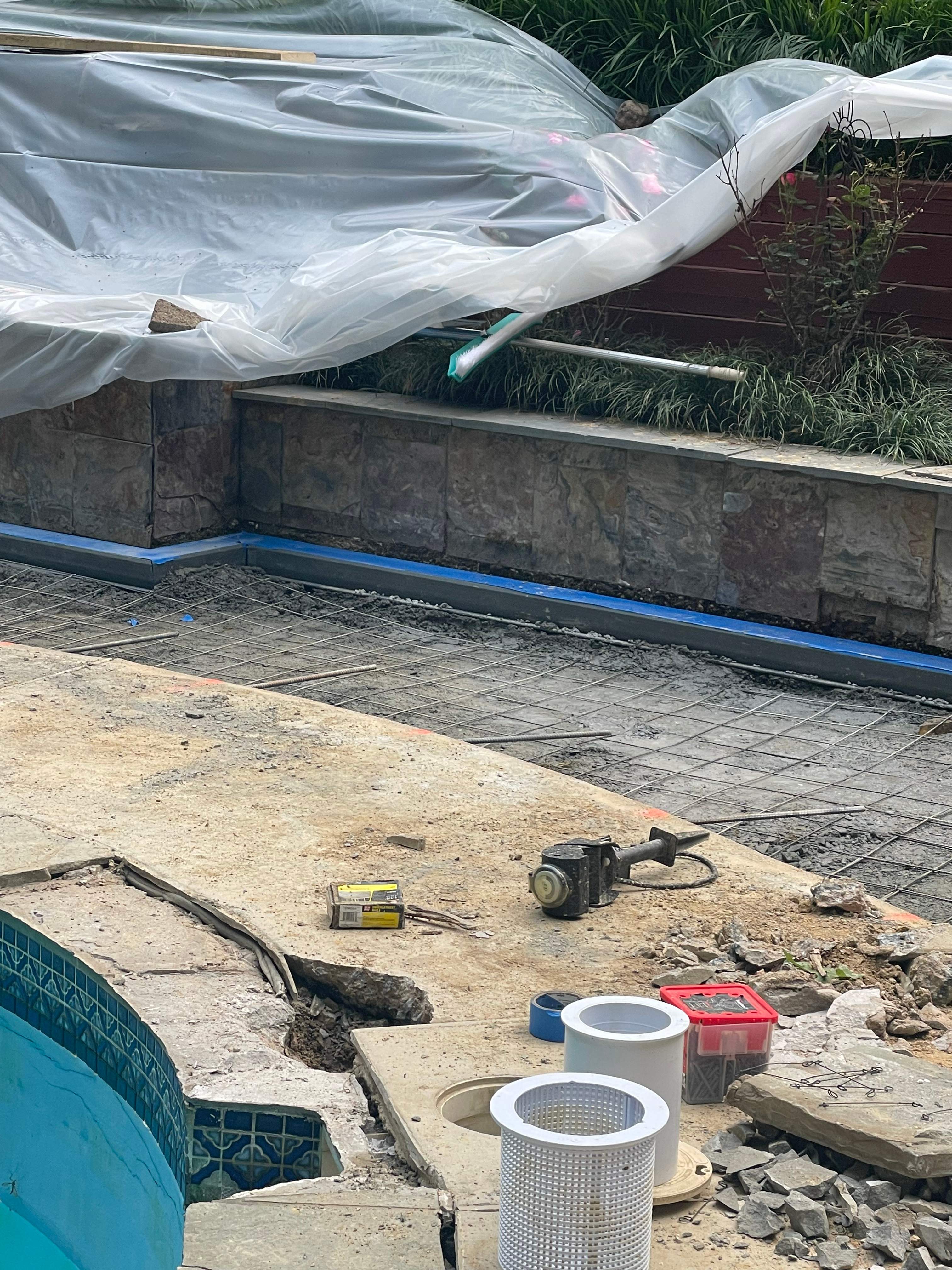 Pool Surround remodel with retaining walls, new waterfall and water slide by Fairfax Contractors, LLC