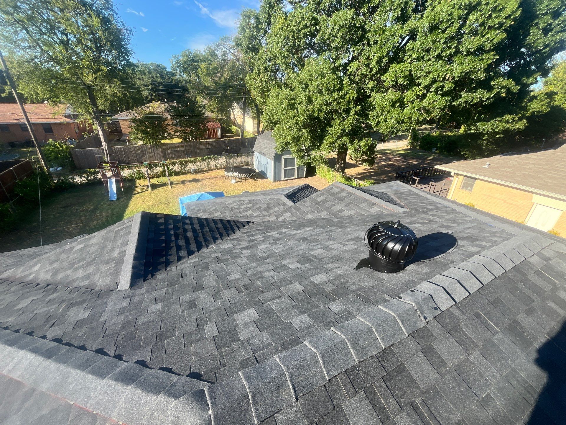 White brick/light gray shutters with IKO Granite Black  by Tejas Roofworks + Restoration