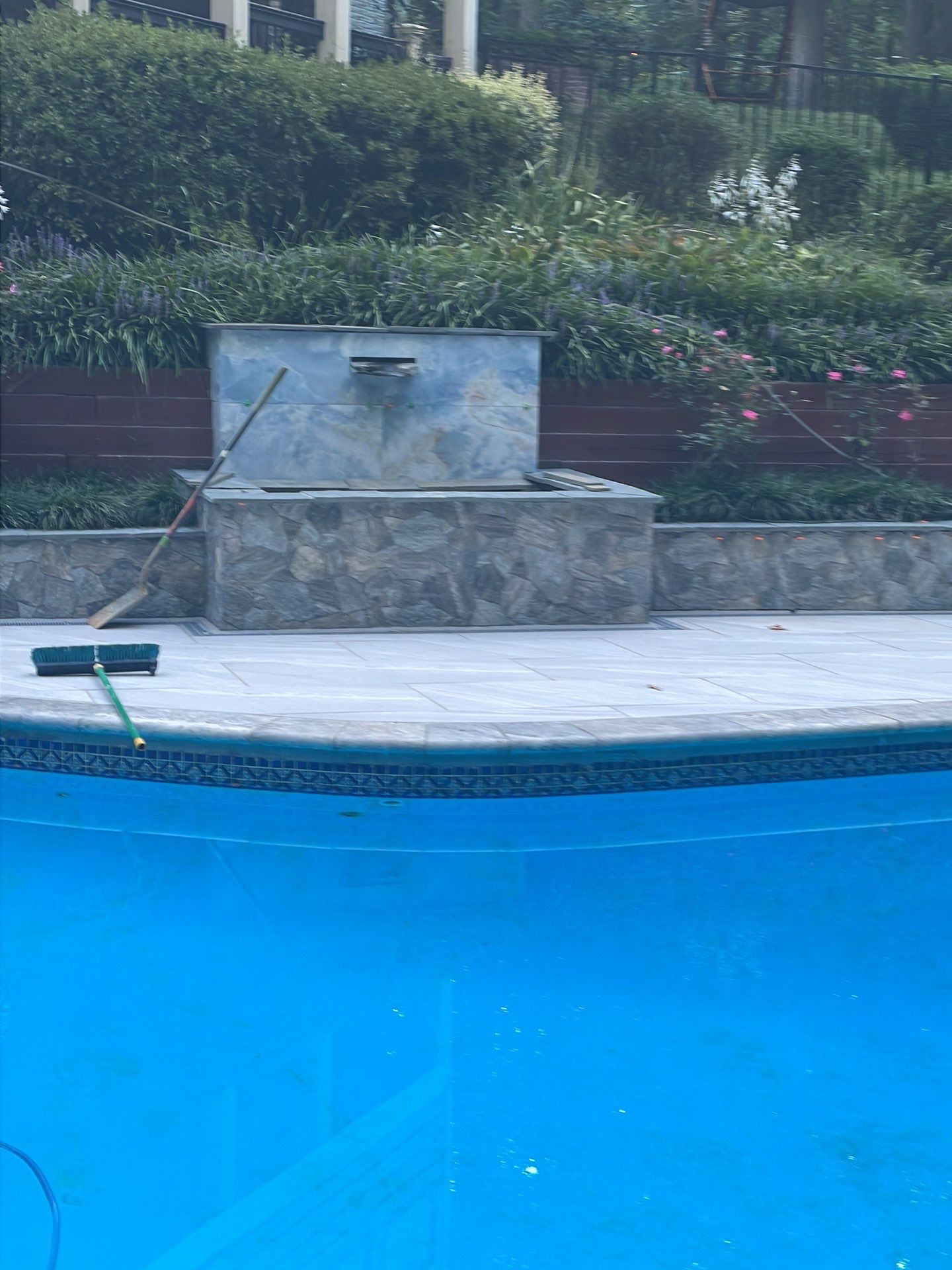 Pool Surround remodel with retaining walls, new waterfall and water slide by Fairfax Contractors, LLC