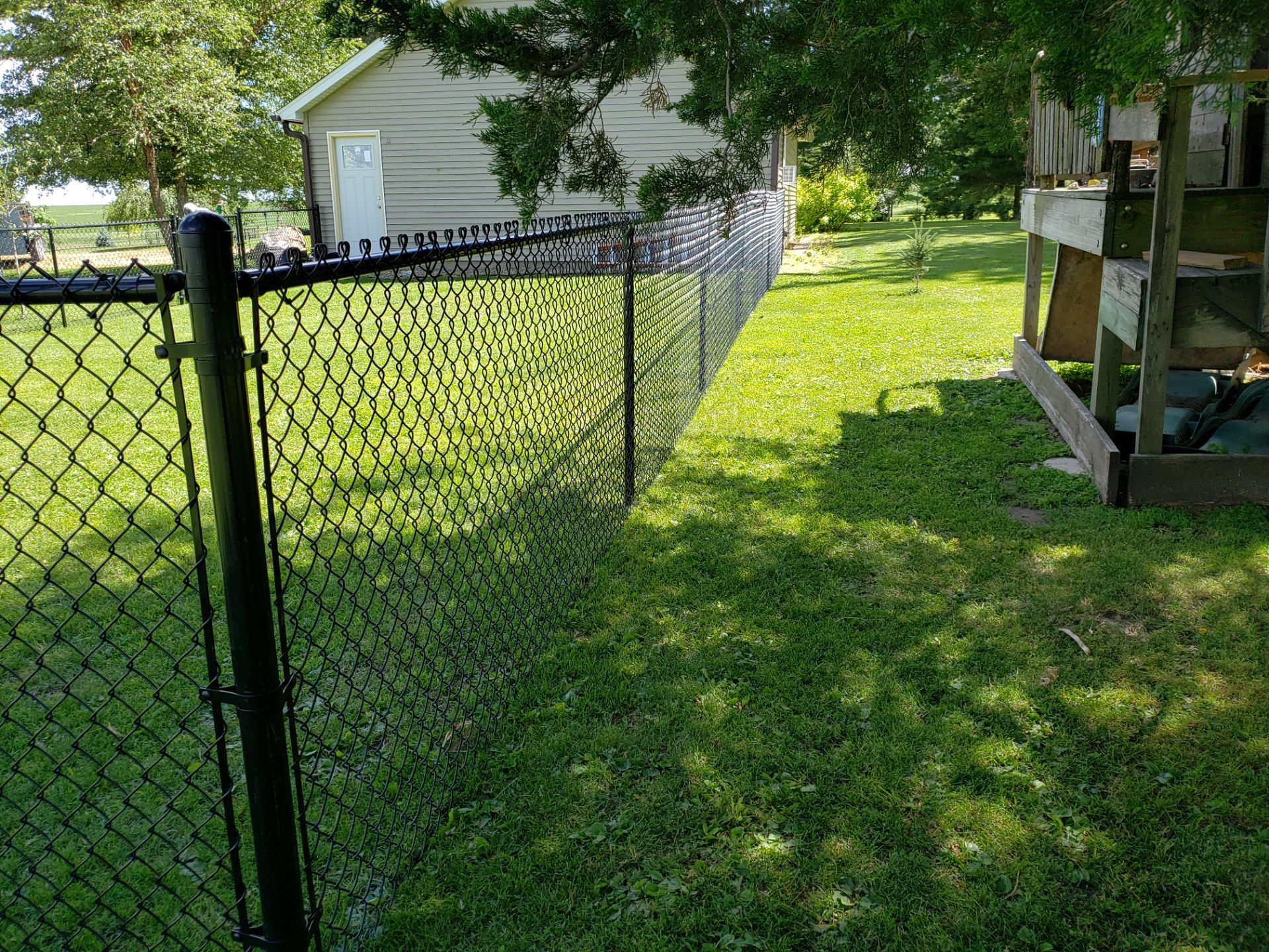 Residential Black Vinyl-Coated Chain Link Fence Installation in Bristow by Perfect Picket Fence and Stain