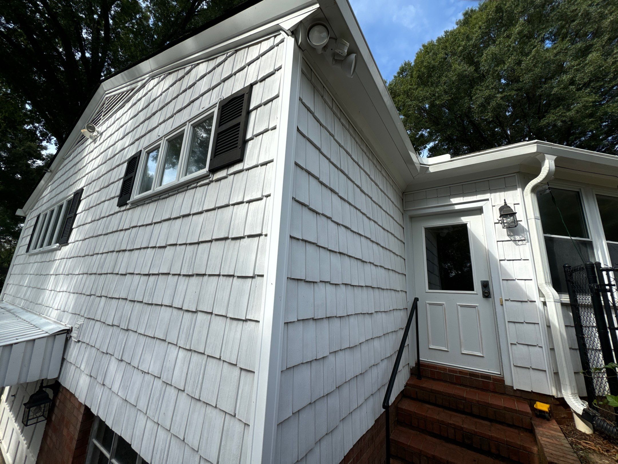 the service being done is washing the exterior shingles and entrance area to remove dirt and grime from the surfaces