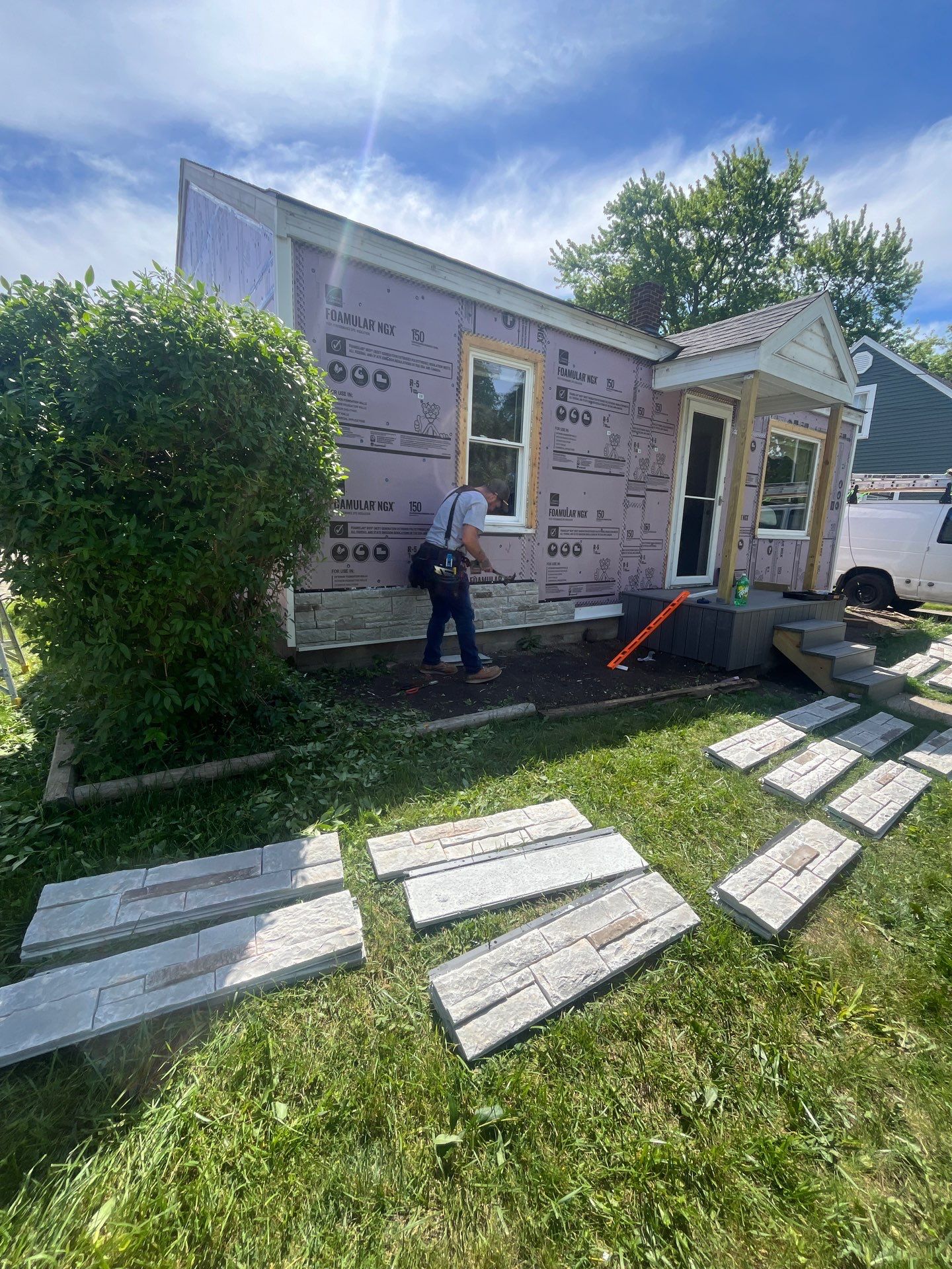 Blue Vinyl Siding and Versetta Stone Exterior Remodel in Bay City by Great Lakes Home Design LLC